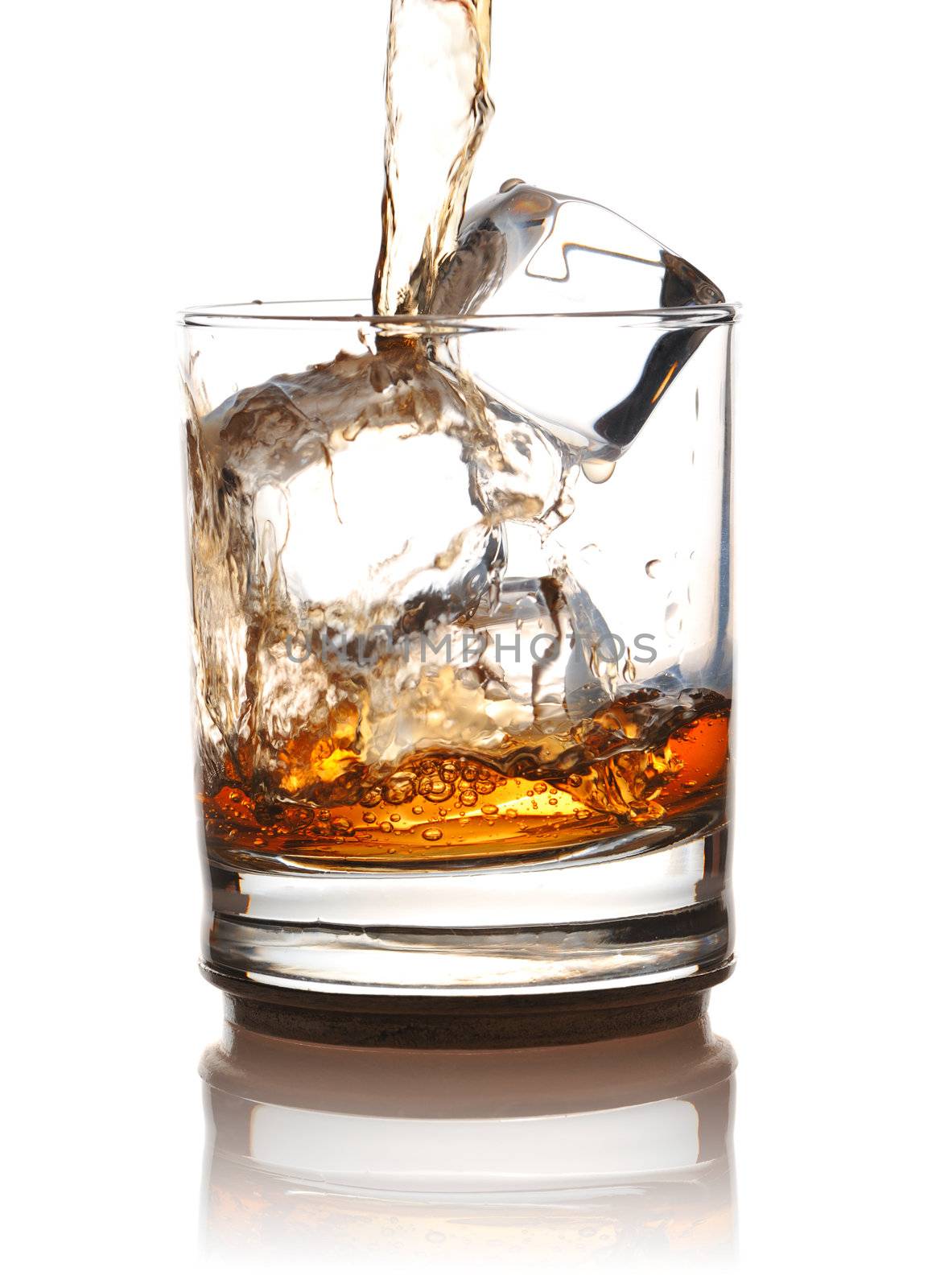 Pouring whiskey in glass with ice isolated on white