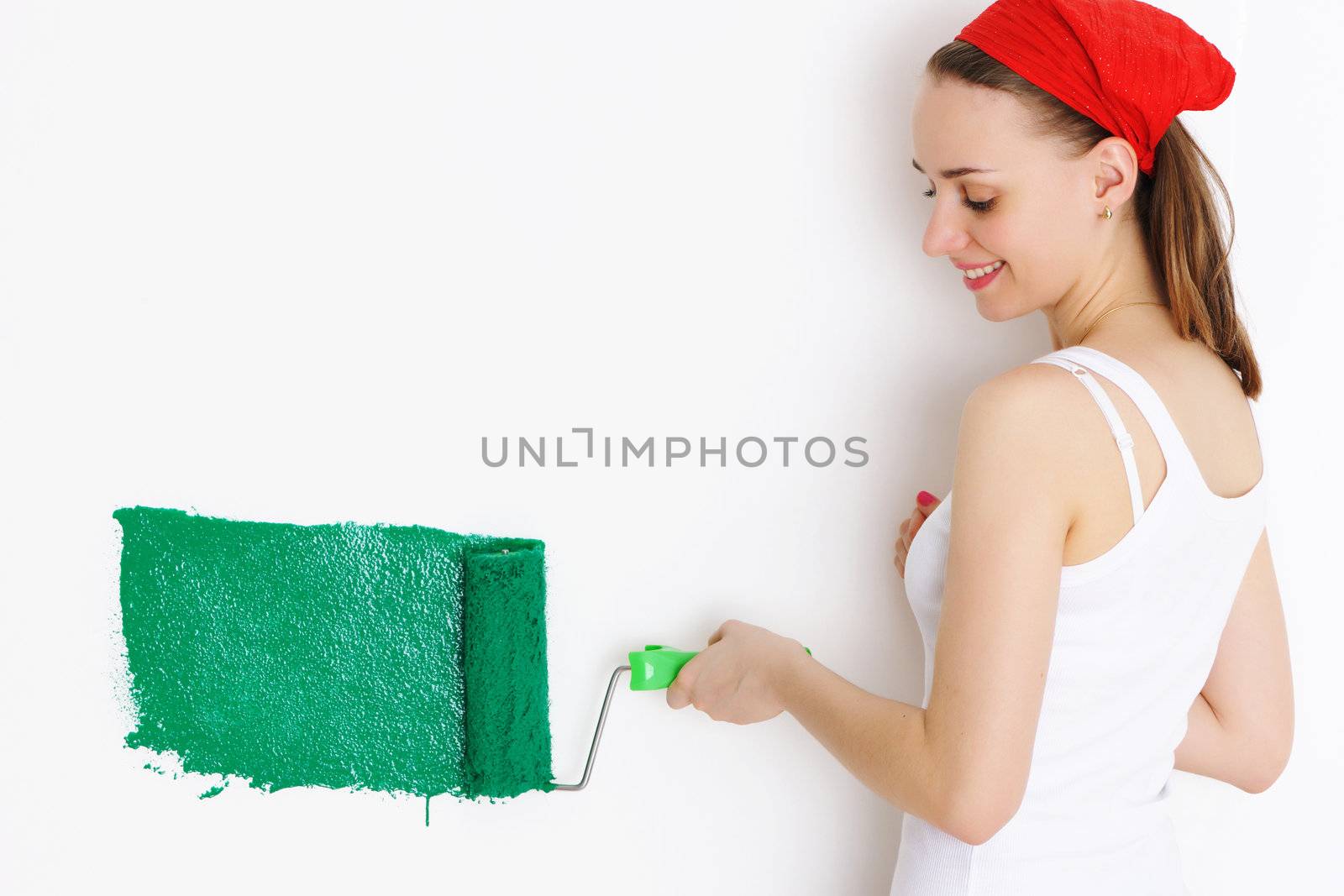 Woman painting interior wall of home with paint roller