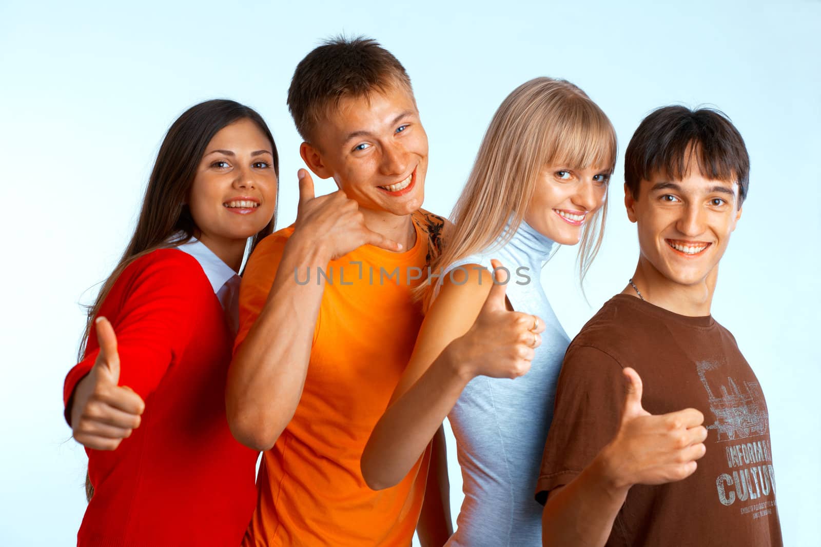 Four young people on white background laughing and giving the thumbs-up sign. 
