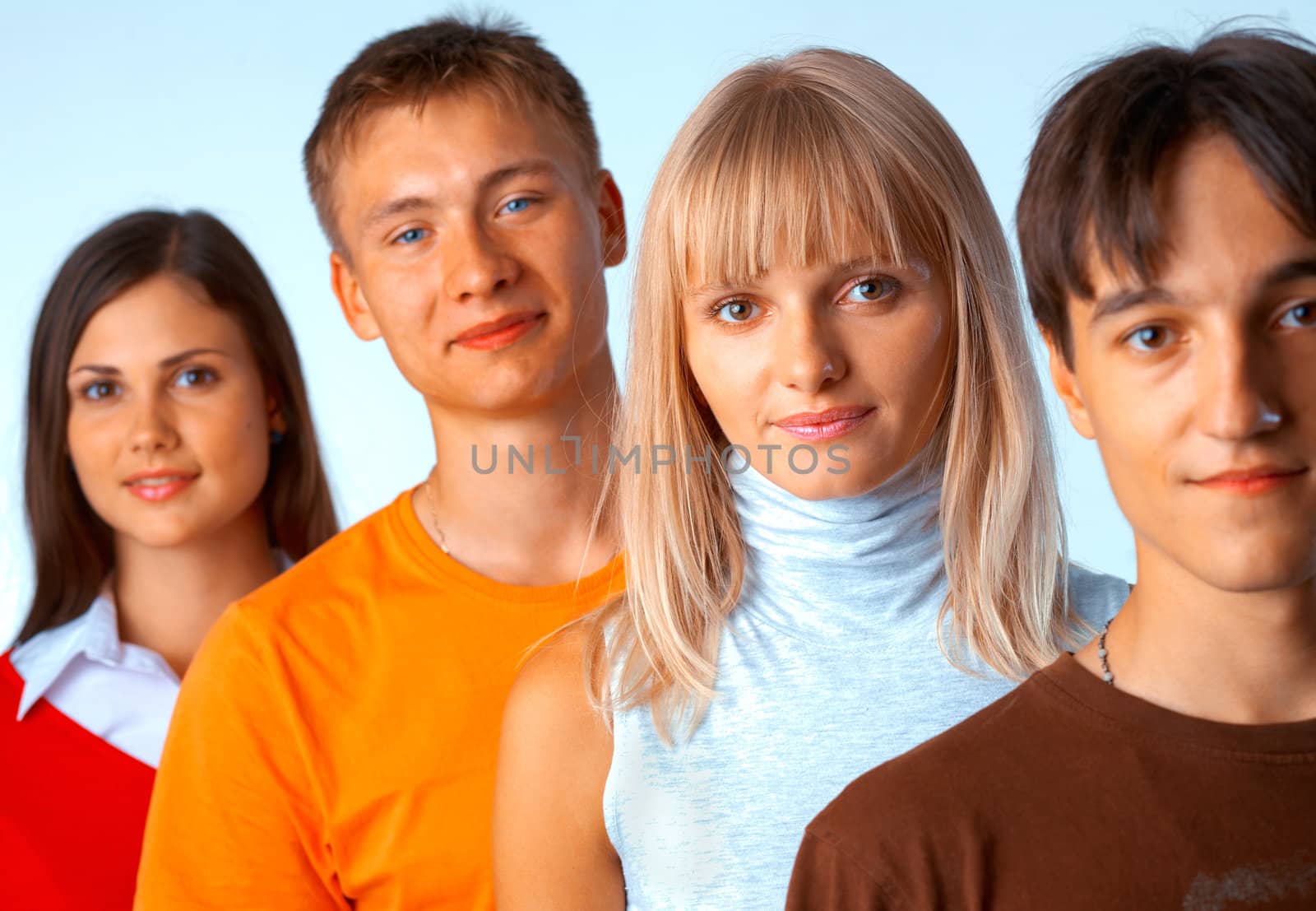 Young people standing in a row on light blue background