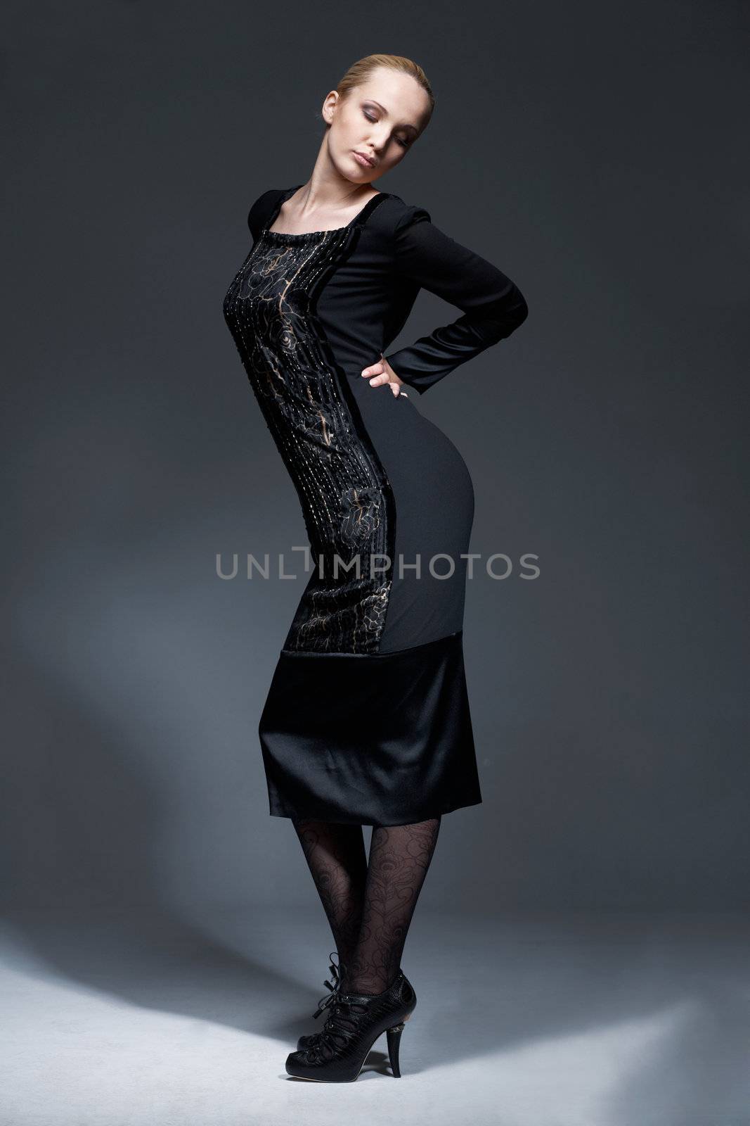 Full length portrait of beautiful model in black retro dress, posing.