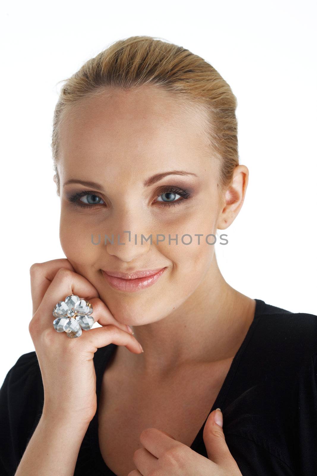 Close-up portrait of a blond model, smiling and holding a hand under her cheek.