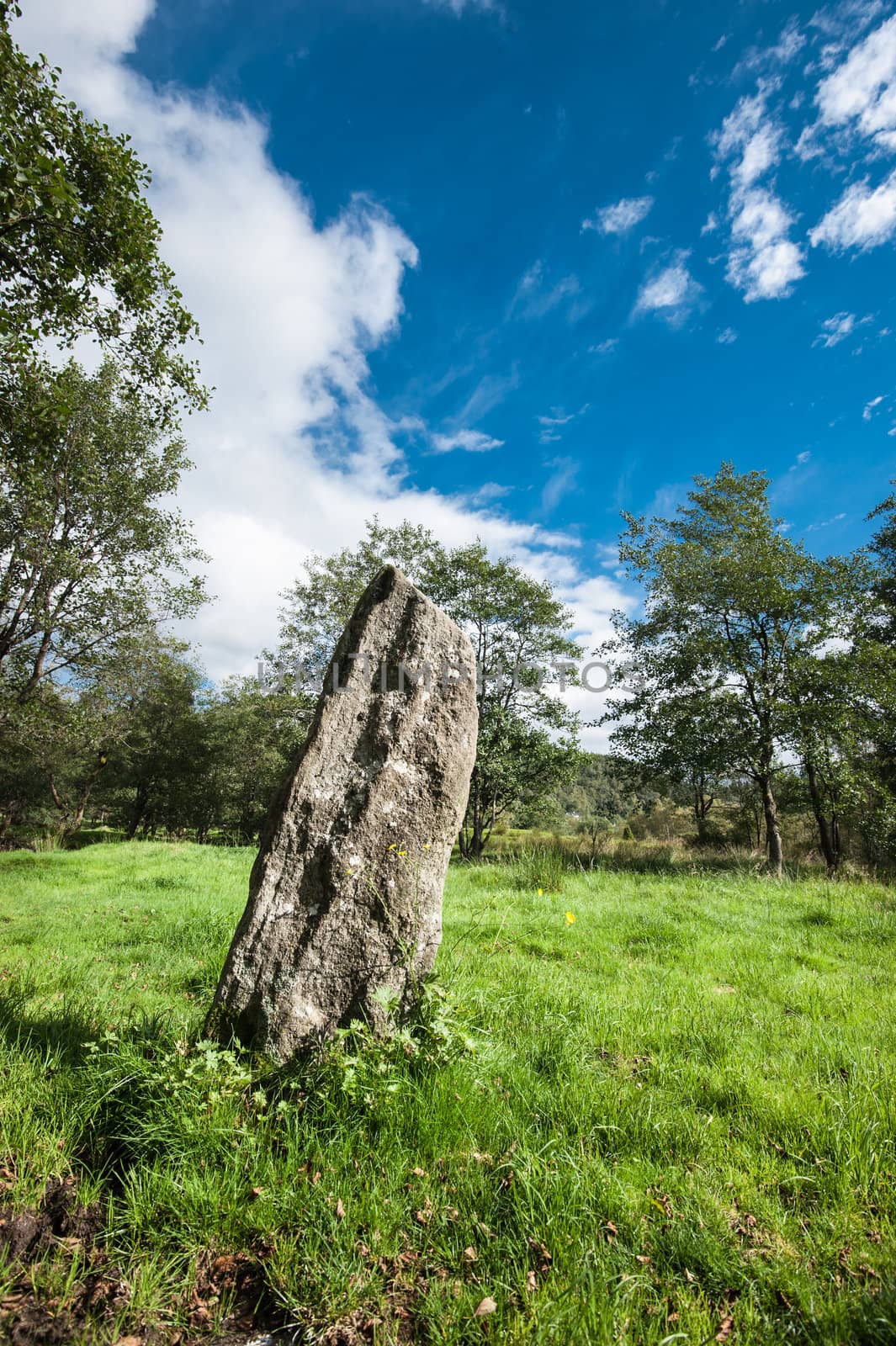 A large stone pointing to the sky on a field