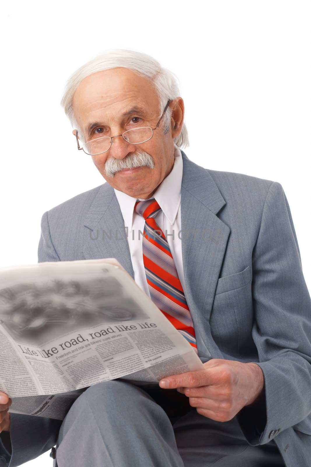 Elder man sitting and reading a newspaper over white.