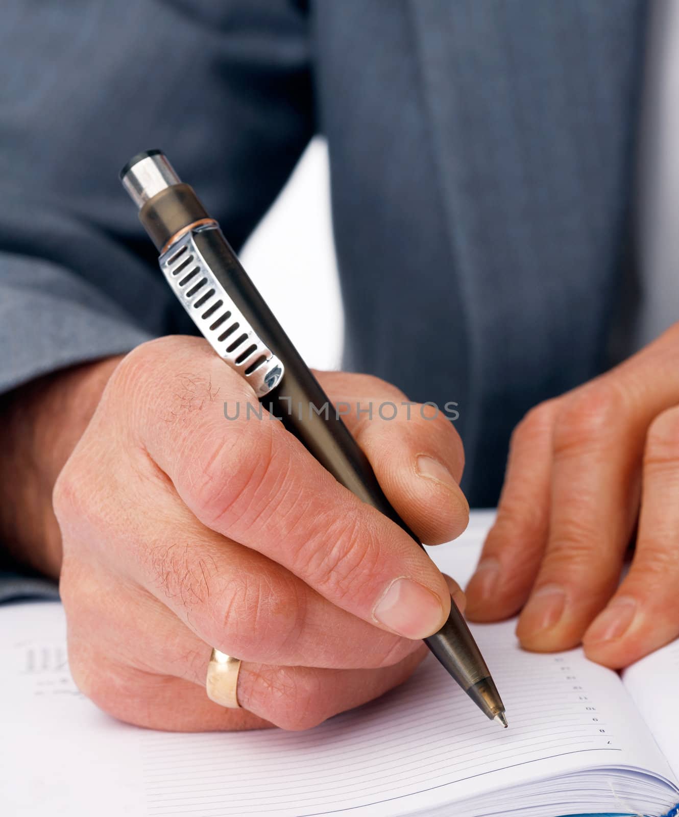 Close-up picture of hands writing in the  business dairy.