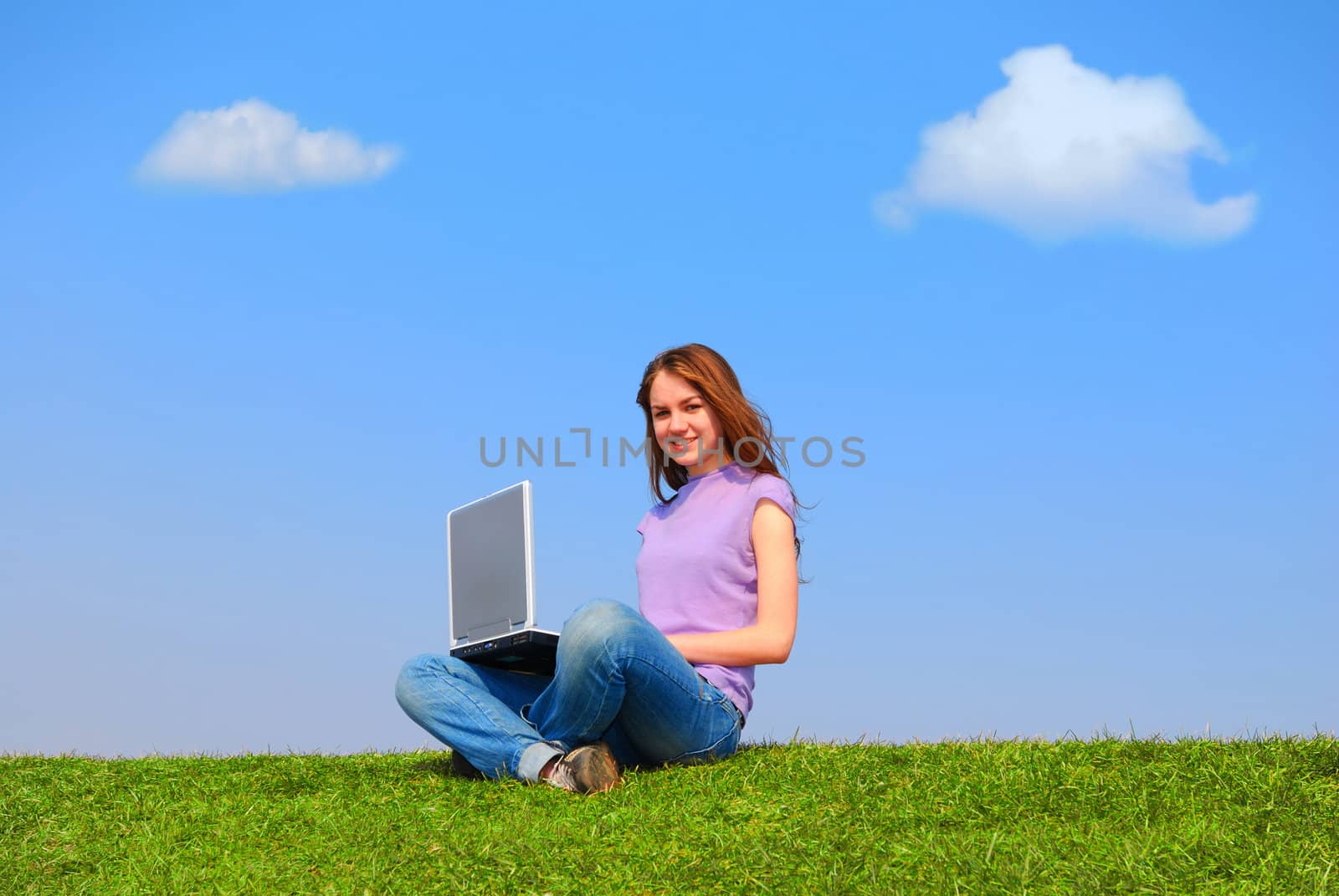 Girl with notebook sitting on grass against sky                                      