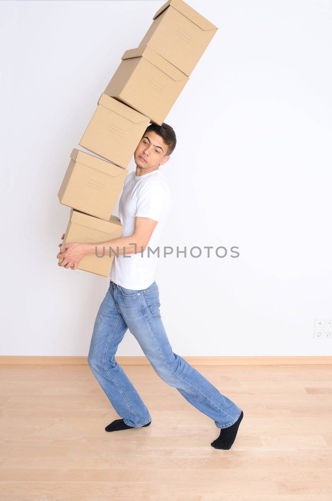 Young man carrying and dropping his stack of moving boxes