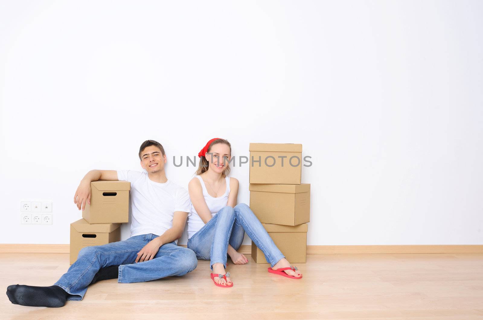 Young couple resting from moving into a new home. Great copy space.