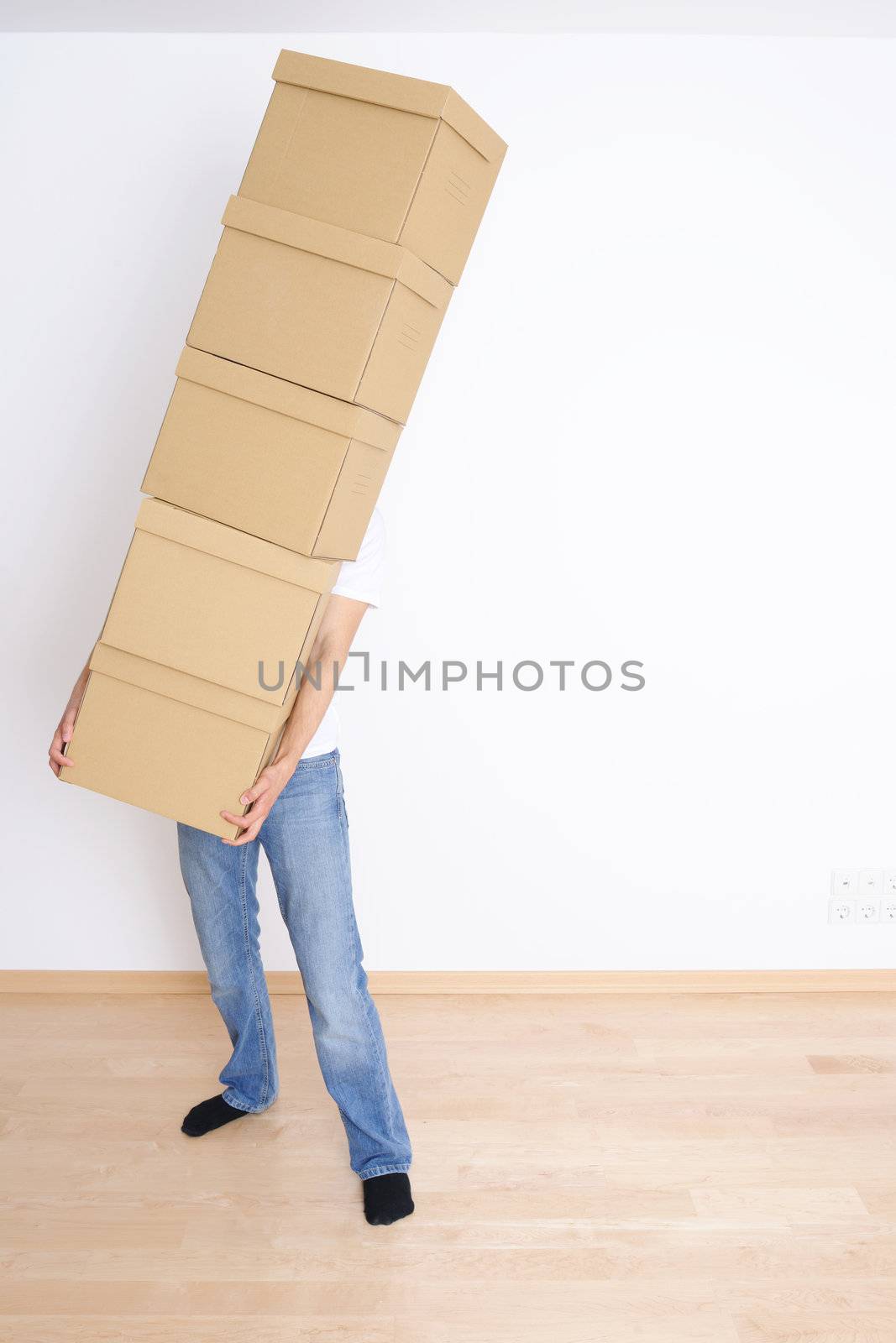 Young man carrying a stack of boxes