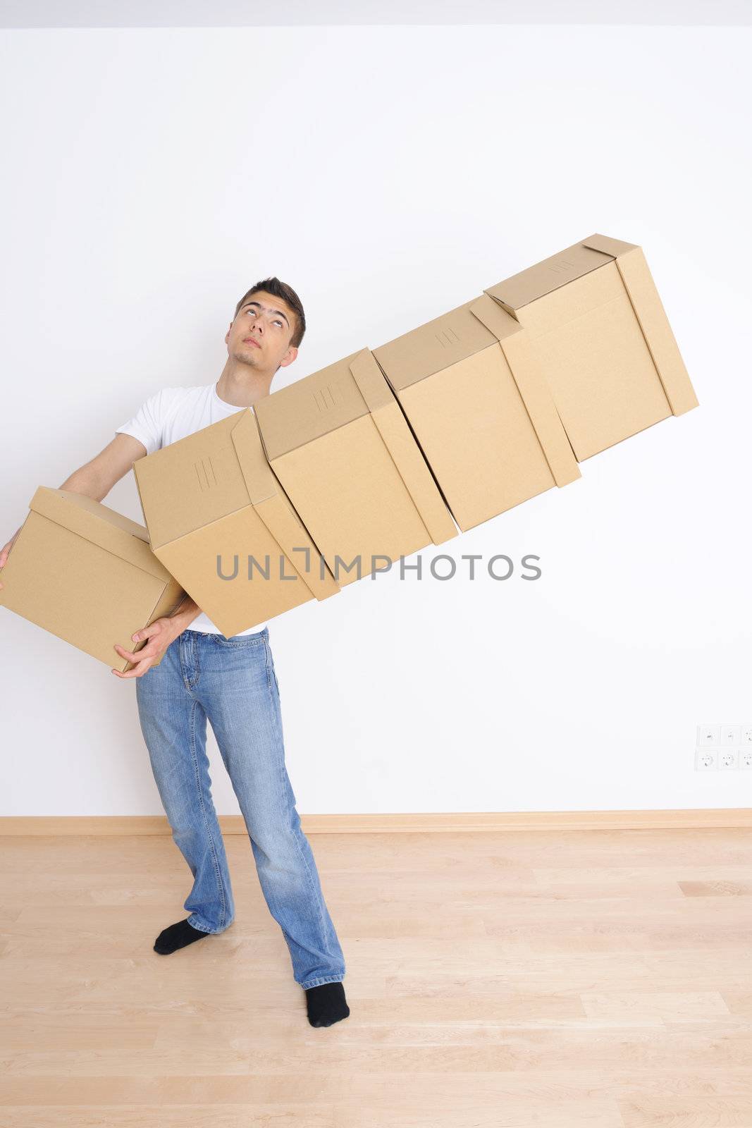 Young man carrying and dropping his stack of moving boxes