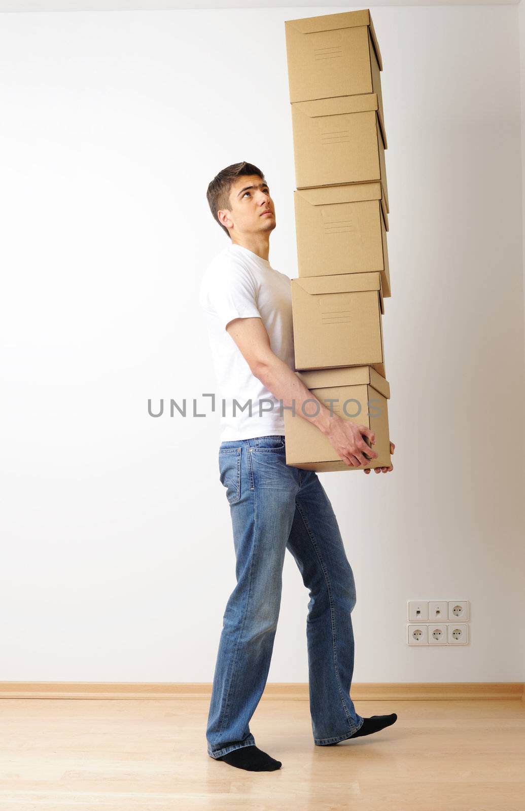 Young man carrying a stack of boxes