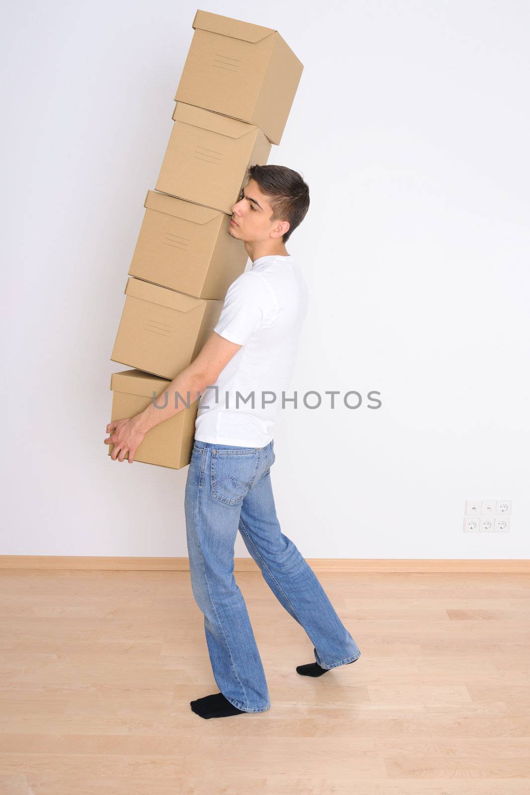 Young man carrying a stack of boxes