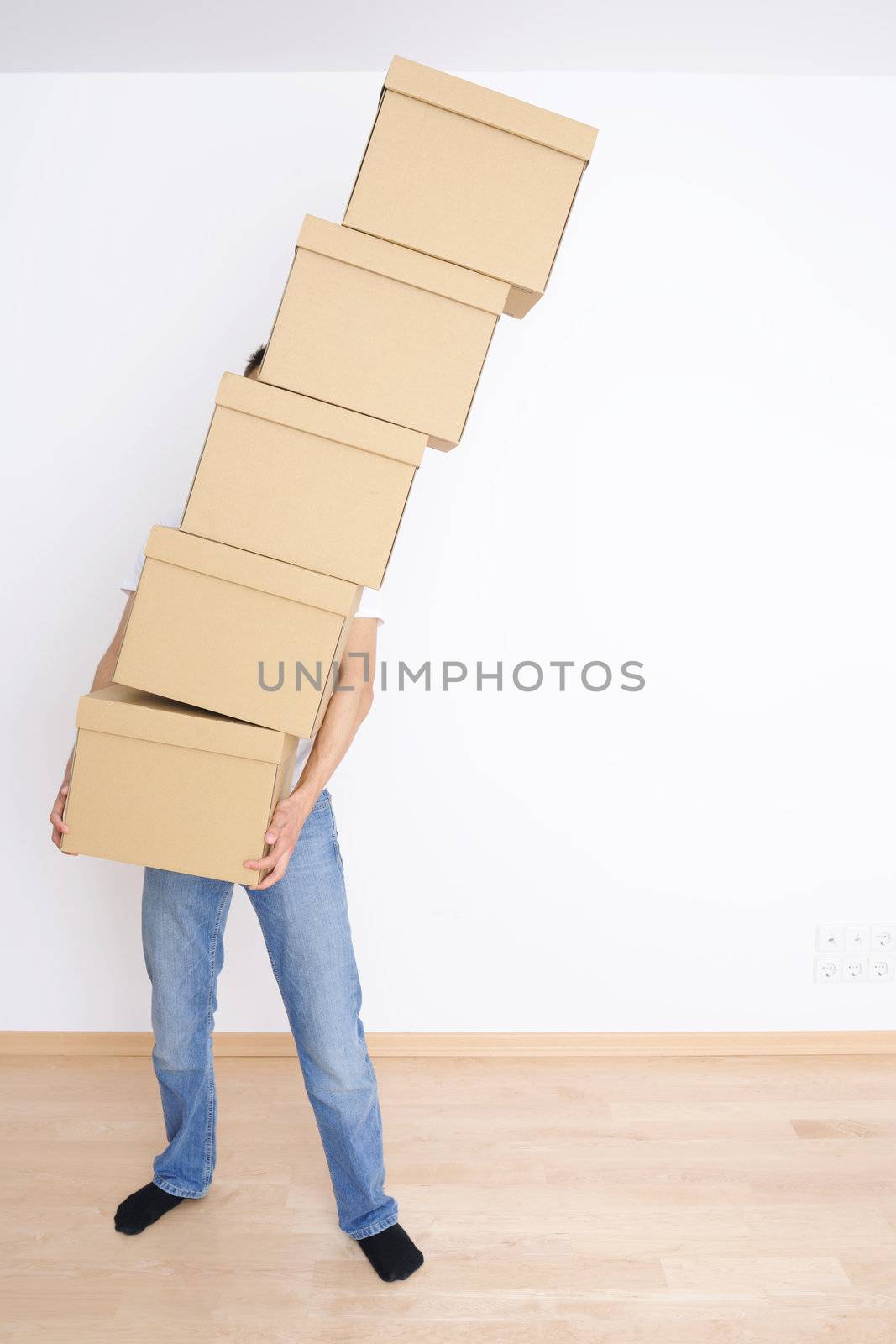 Young man carrying and dropping his stack of moving boxes