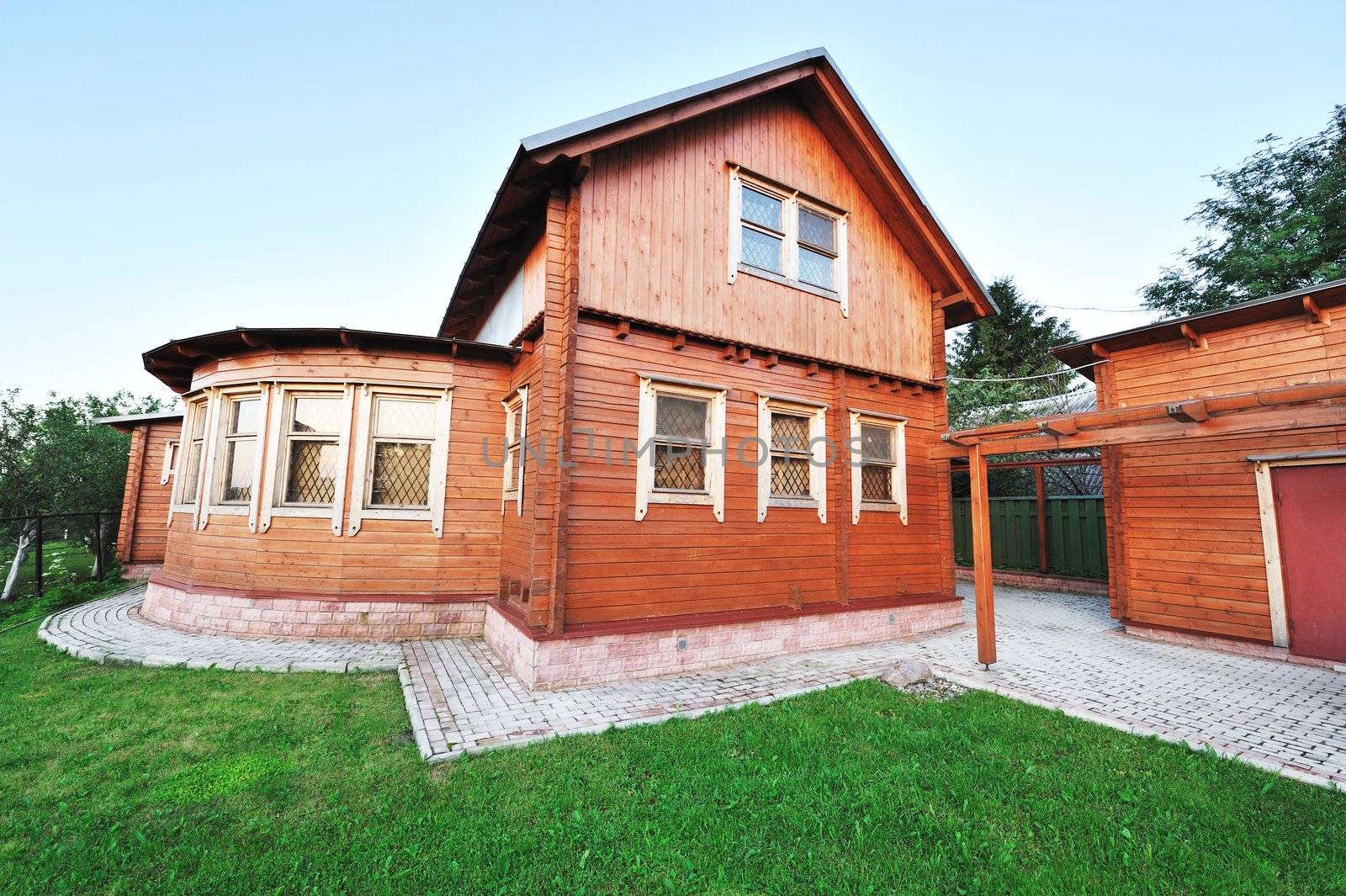 Wooden house with meadow in front of it