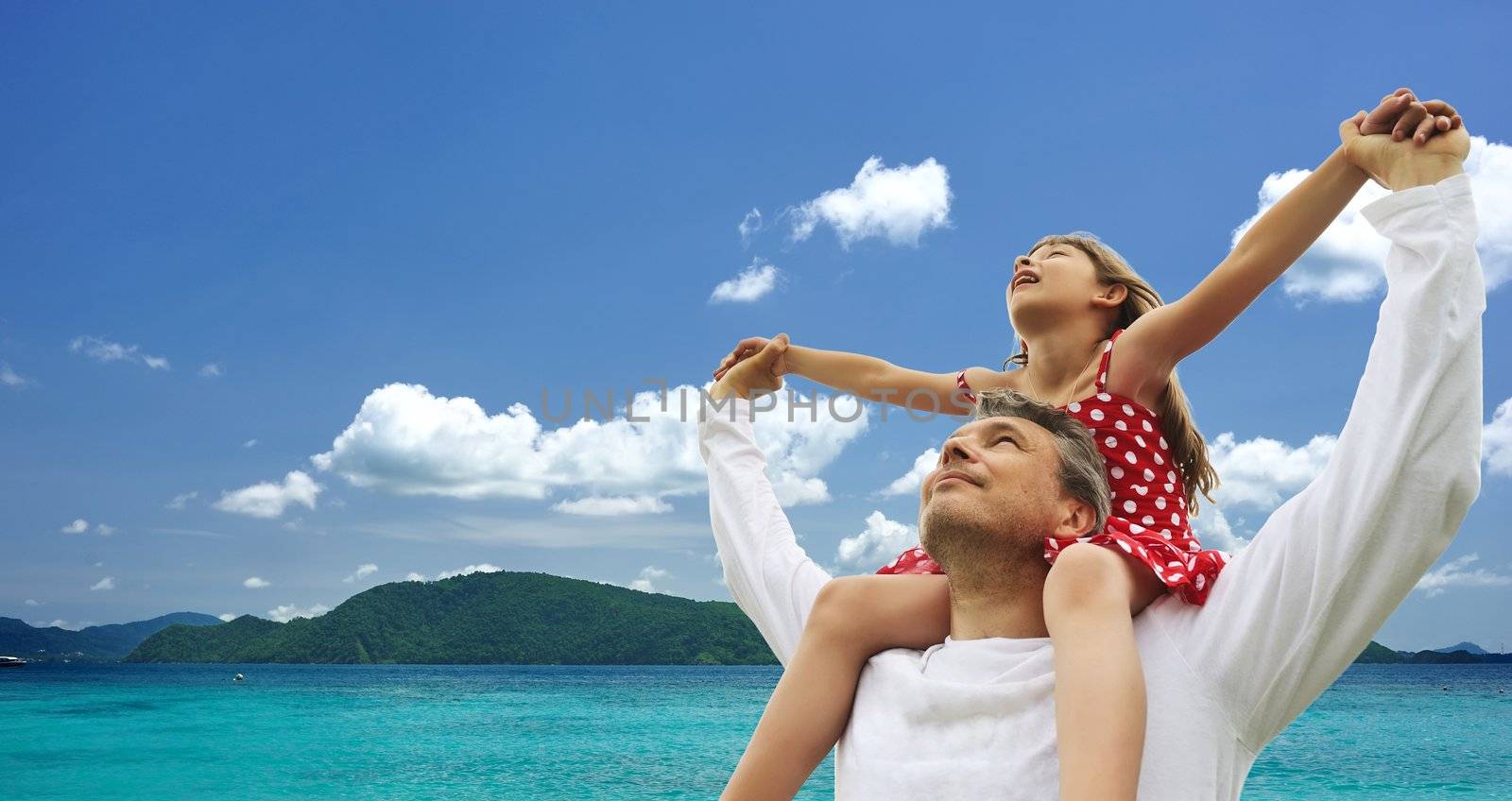 Father and daughter against sky 