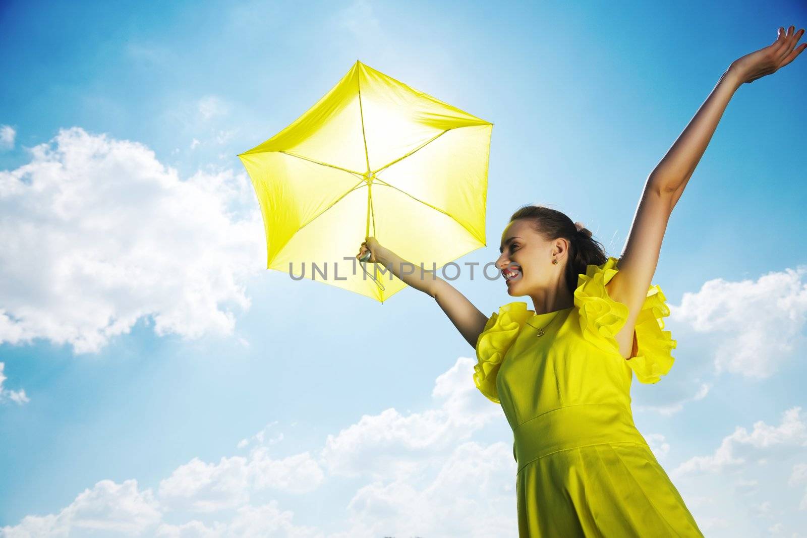 Woman holding umbrella against sun and sky