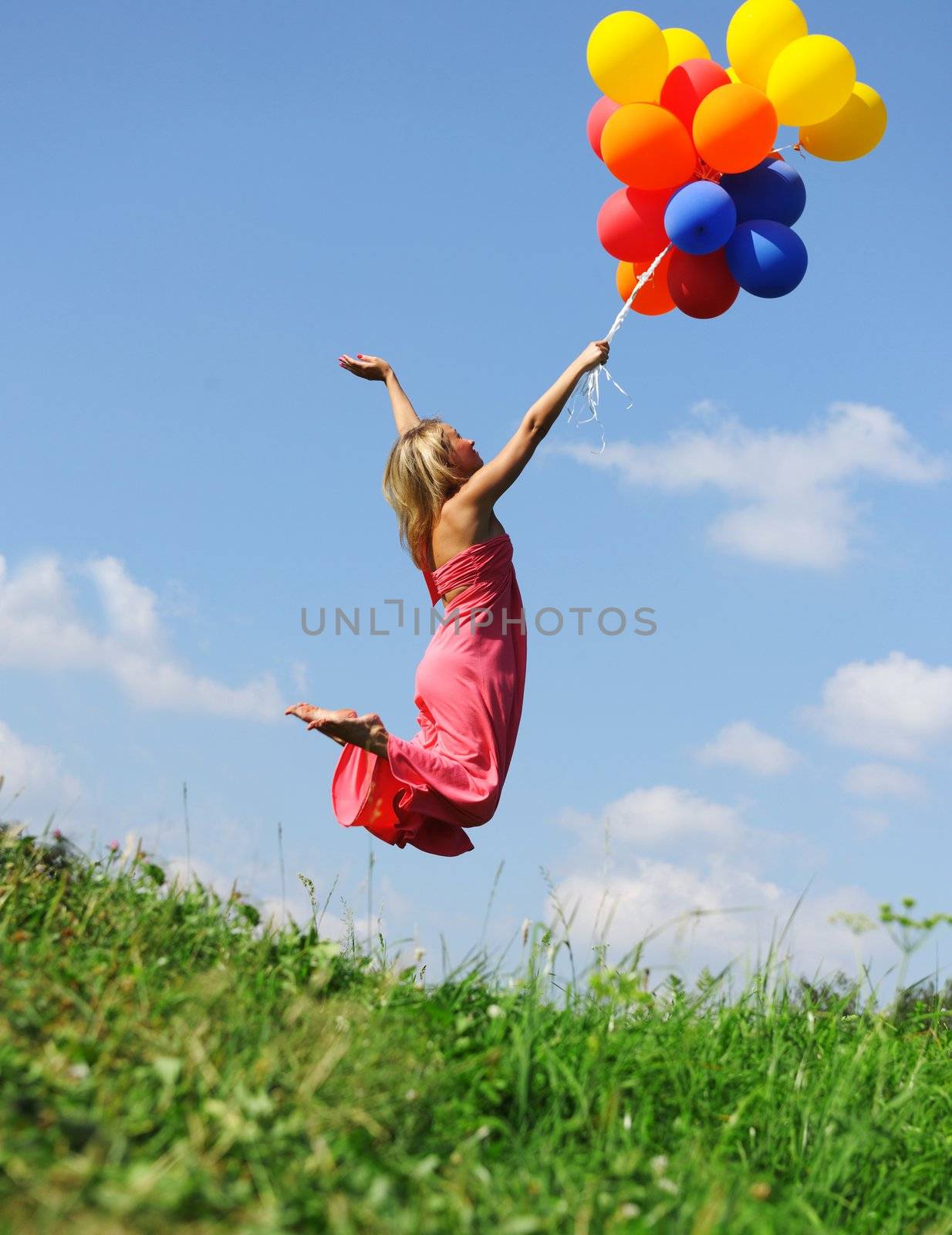 Girl jumping with balloons trying to fly