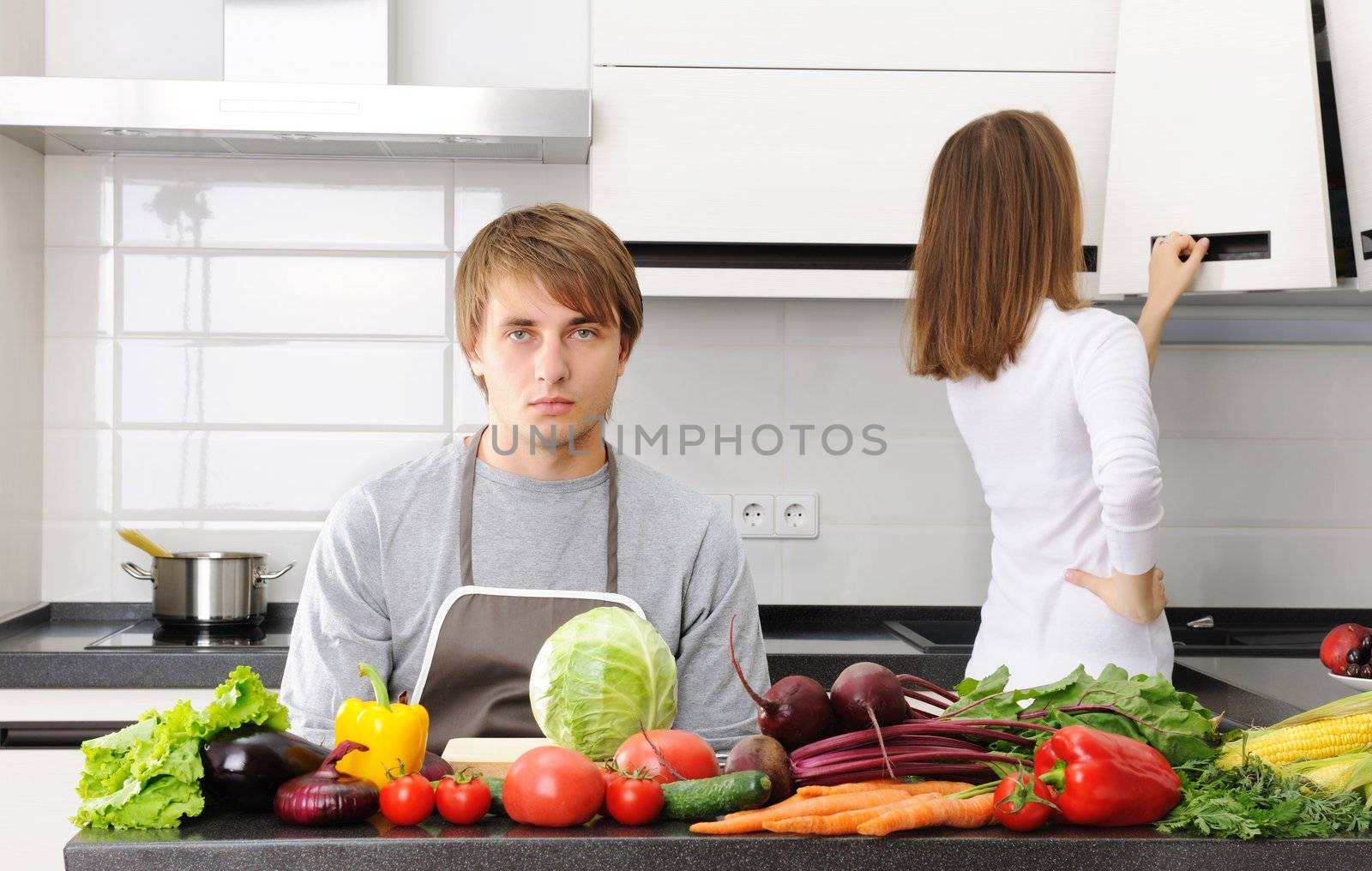 Man unhappy with cooking sitting in kitchen