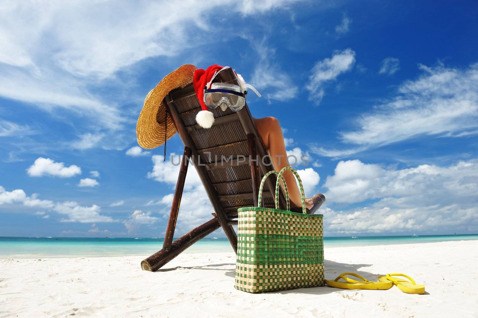 Woman relaxing on the beach in santa's hat