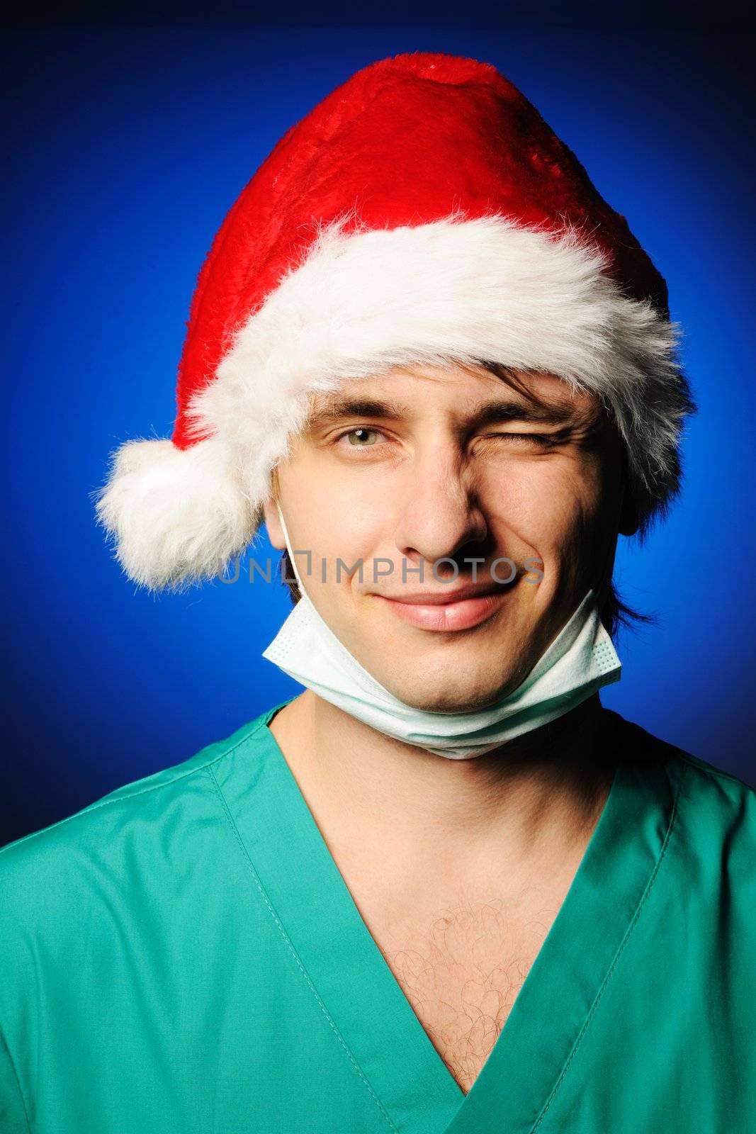 Surgeon with mask in Santa's hat smiling and winking