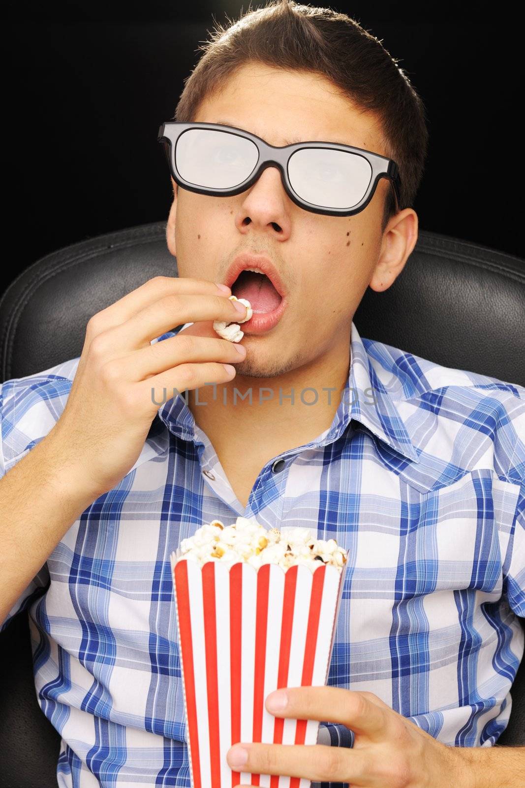 Young man watching movie in 3D glasses at cinema