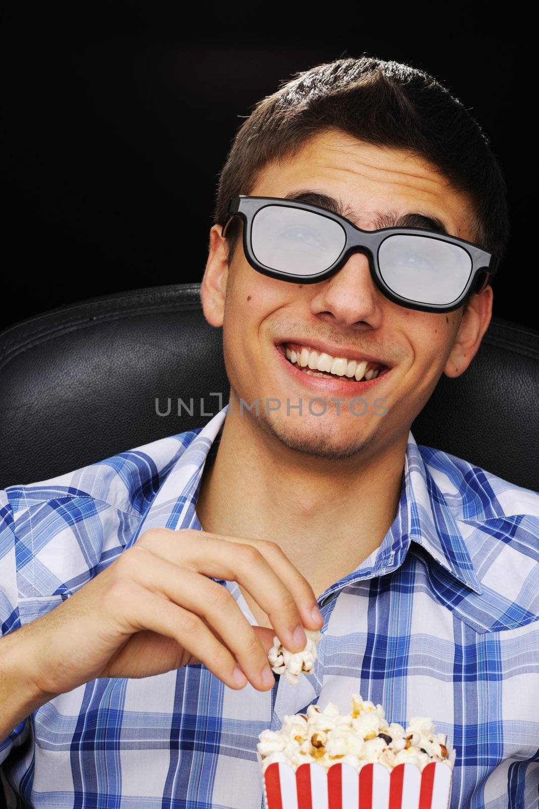 Young man watching movie in 3D glasses at cinema