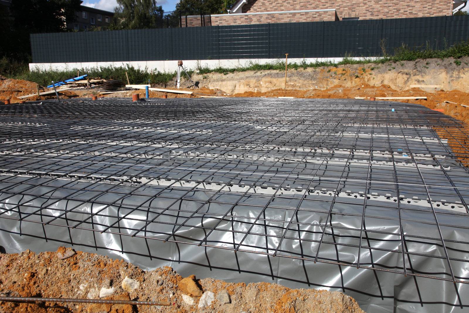 New foundations and floor left to cure and dry under the cover of plastic sheeting on the building site of a new house