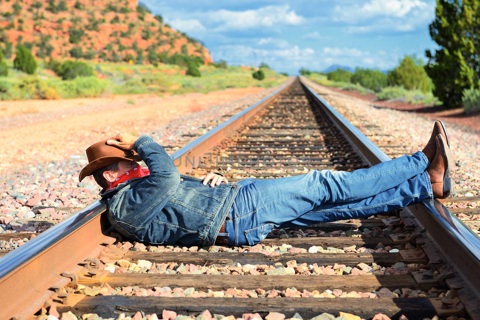 famous cow-boy boots and feets across train tracks 