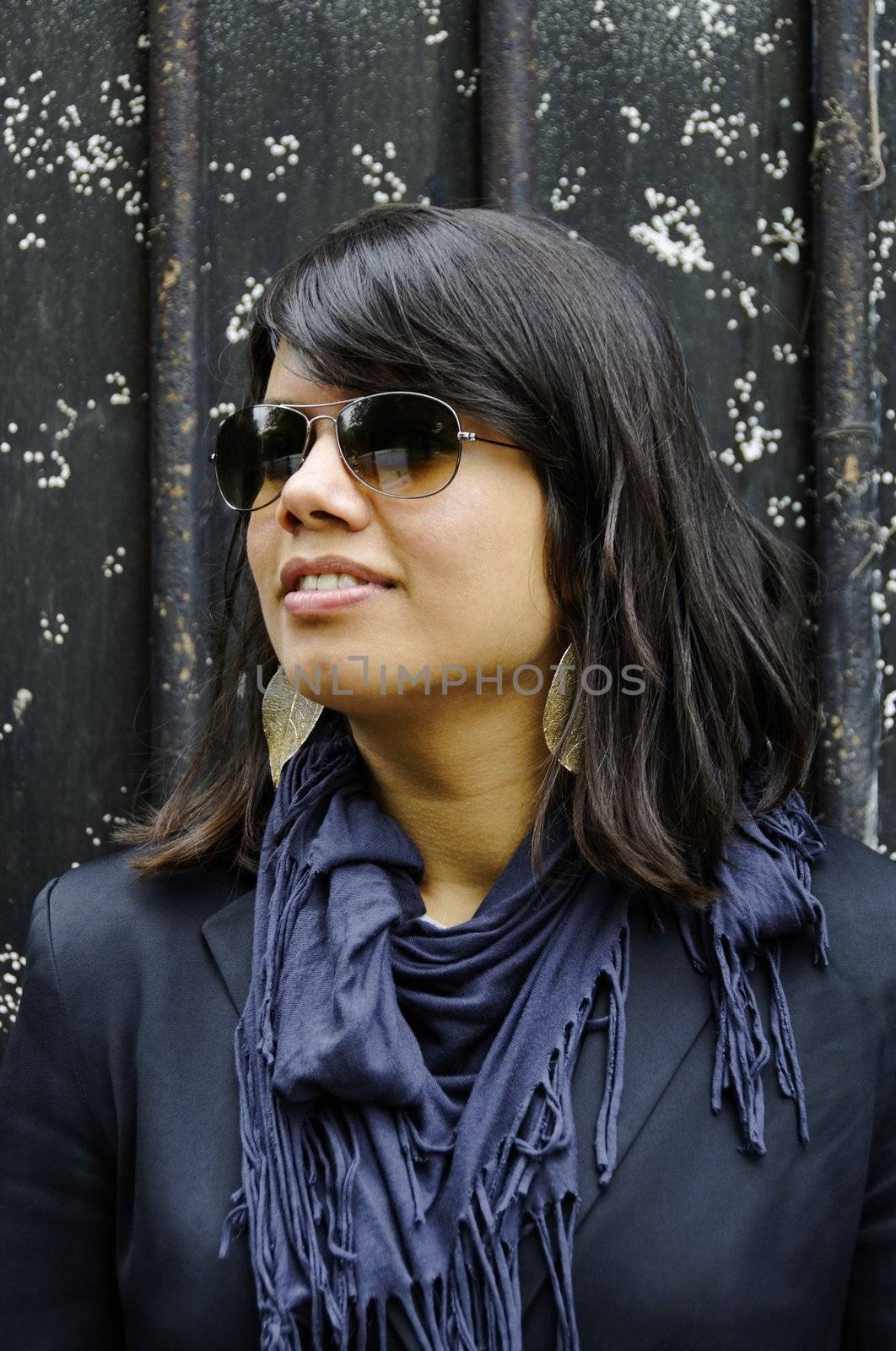 Young Asian woman wearing sunglasses portrait, dark background