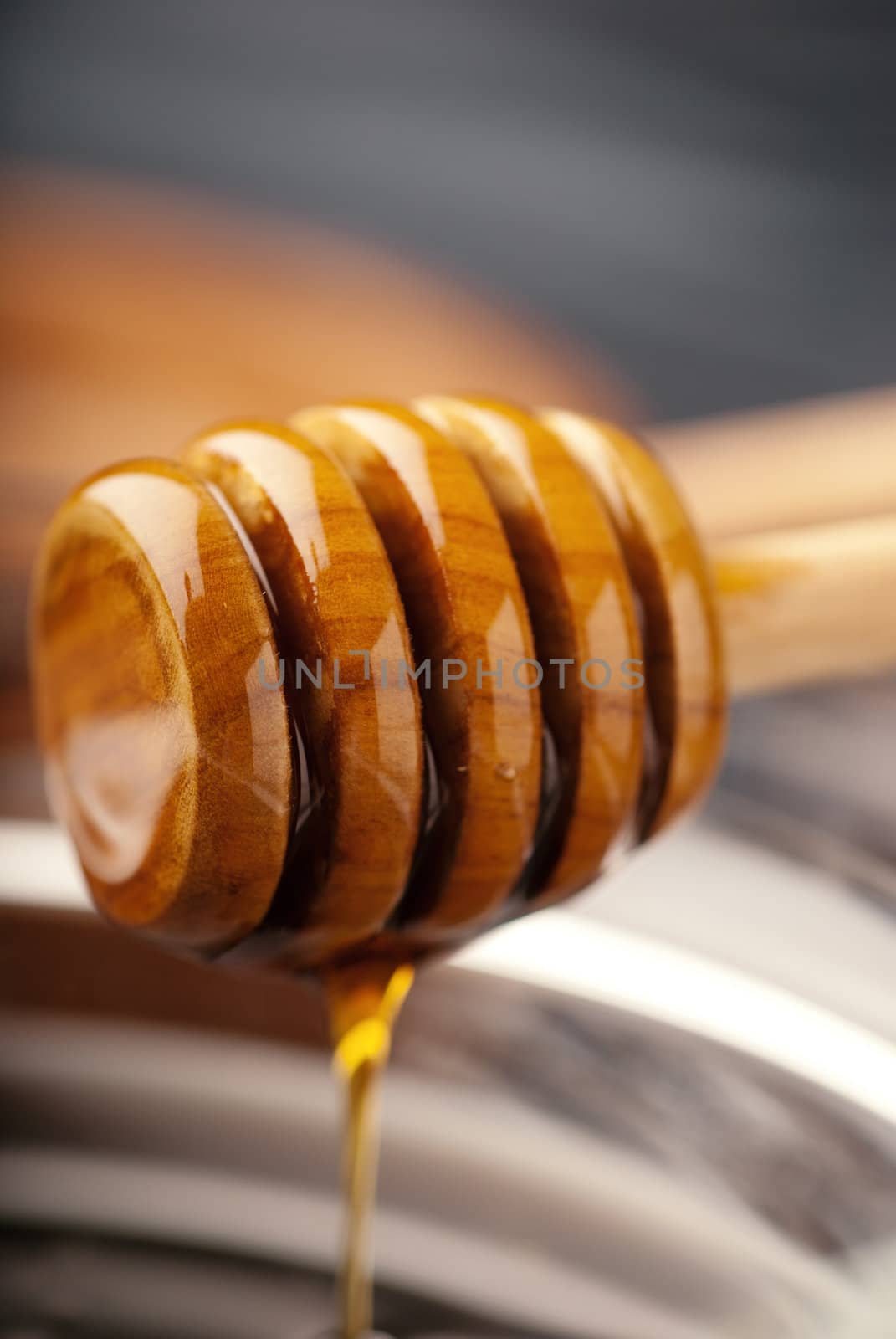 Thin focus showing a wooden honey drizzler 