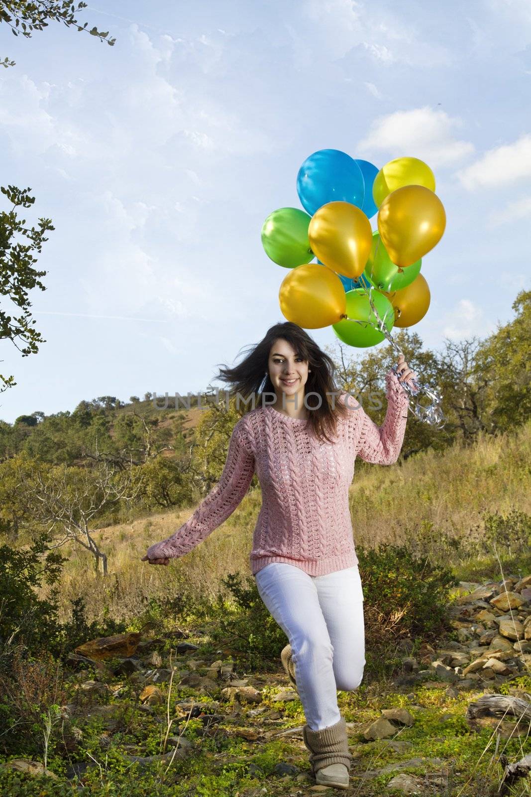 View of a beautiful girl with balloons on nature.