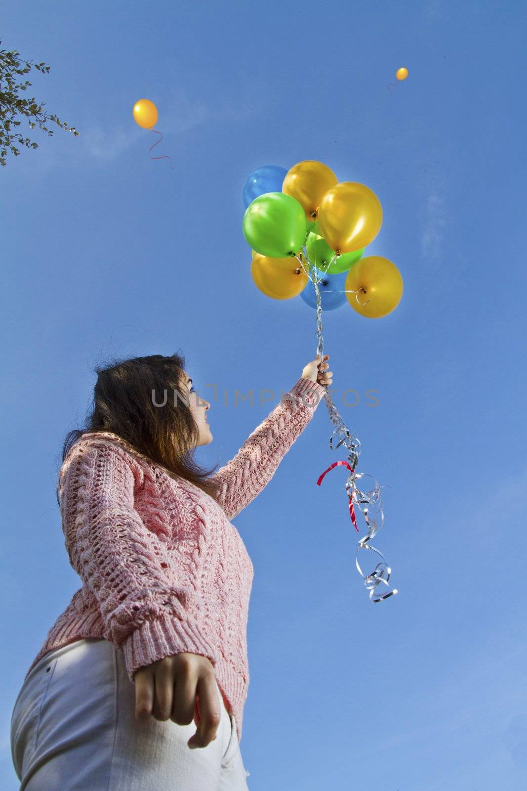 View of a beautiful girl with balloons on nature.