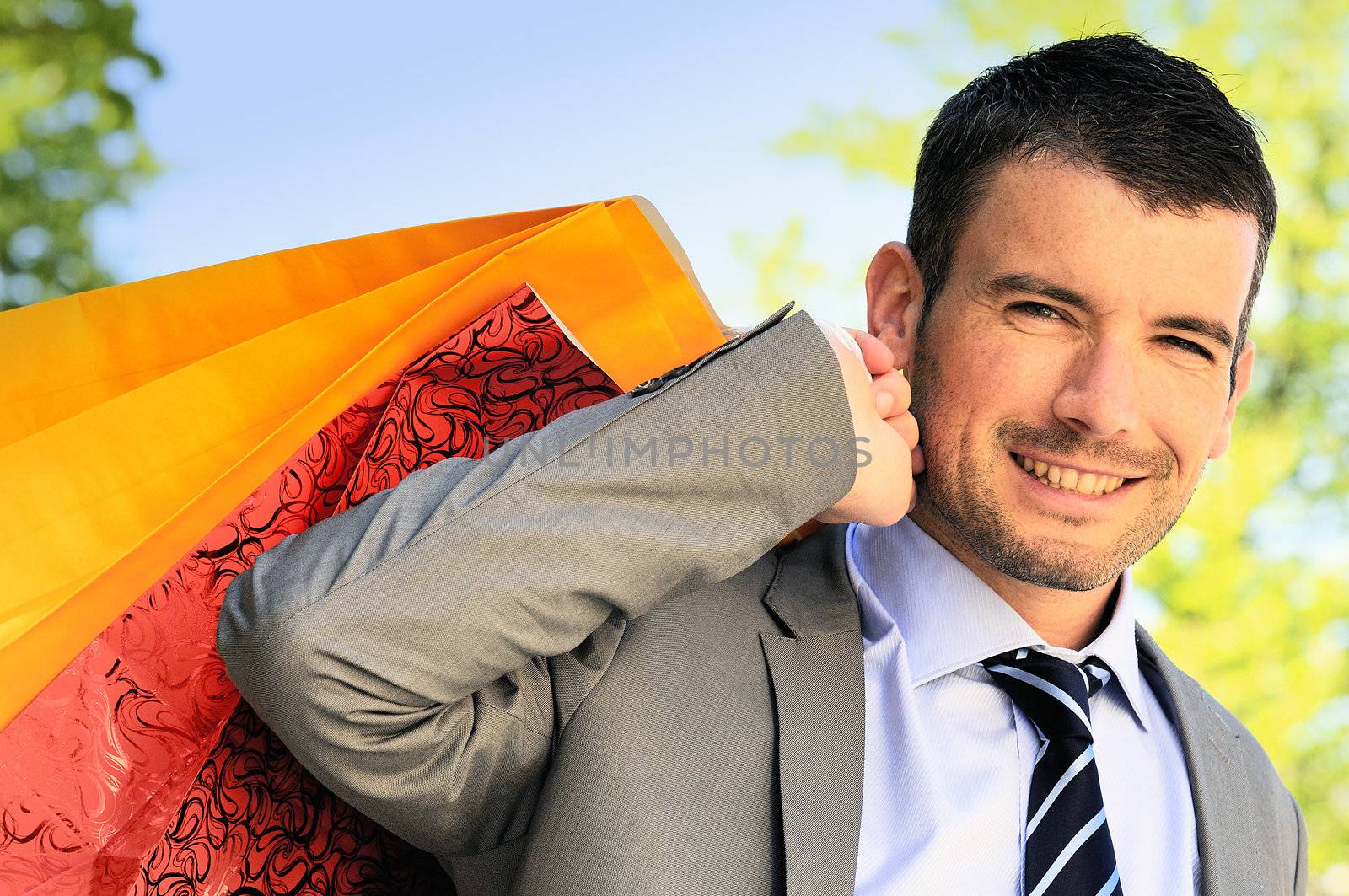 great businessman outdoor with colored shopping bags