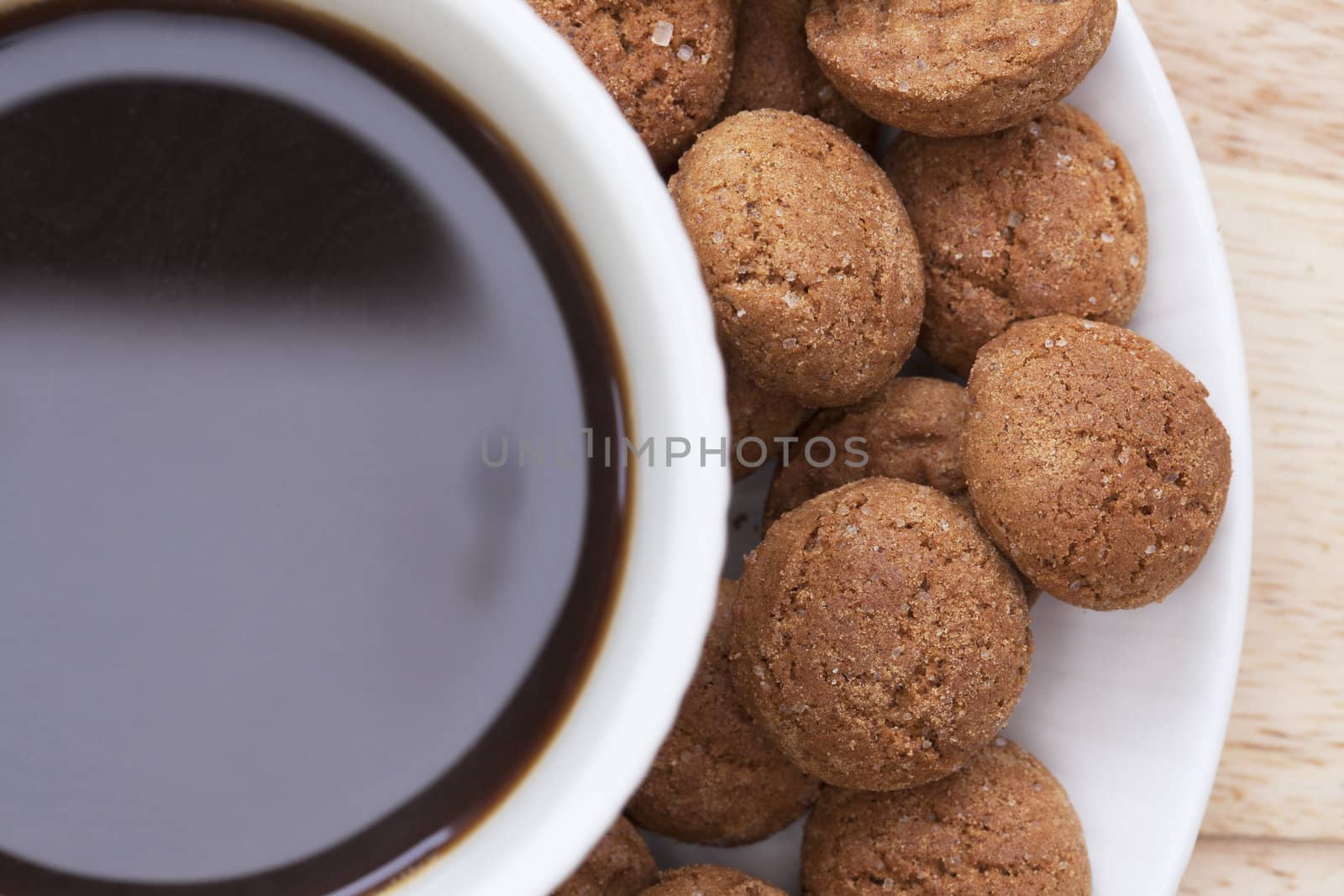 Close up of cup of coffee with kruidenootjes, Dutch spice cookes, around edge.  Shot from directly above