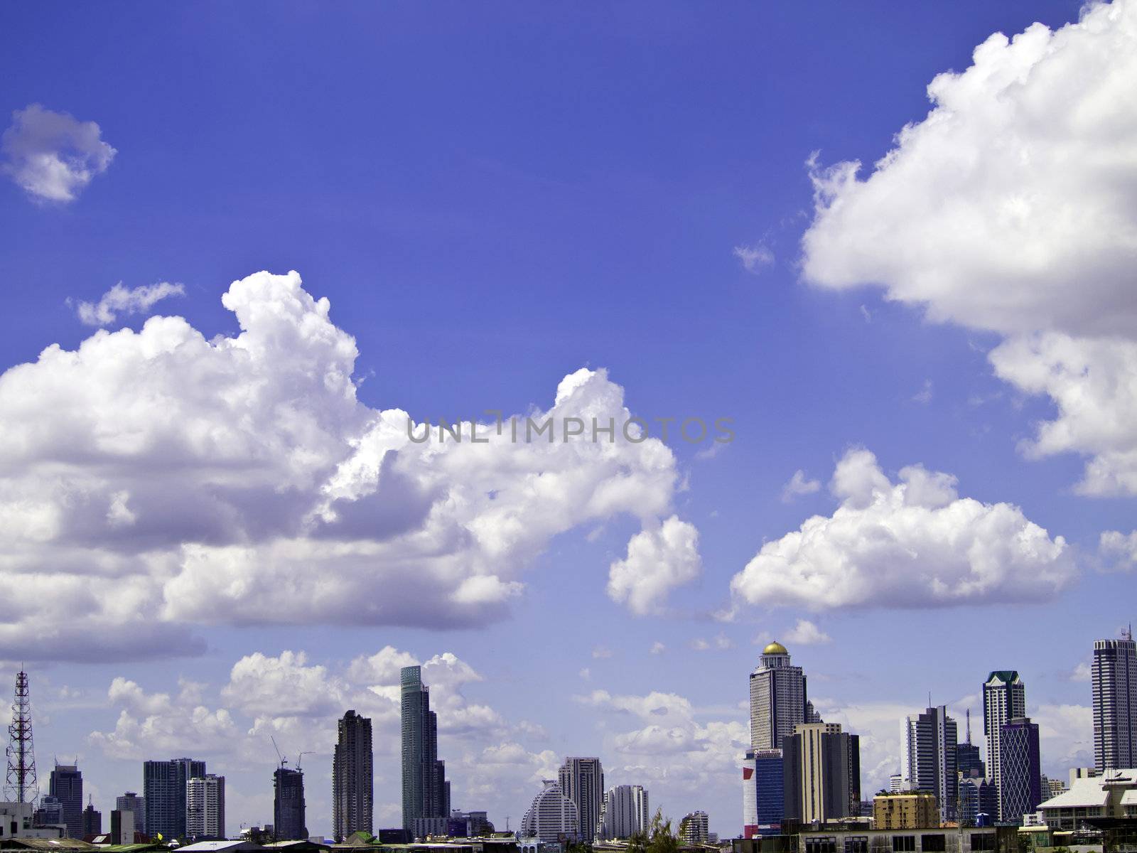 Blue sky with cloud, a city with tall buildings by siraanamwong