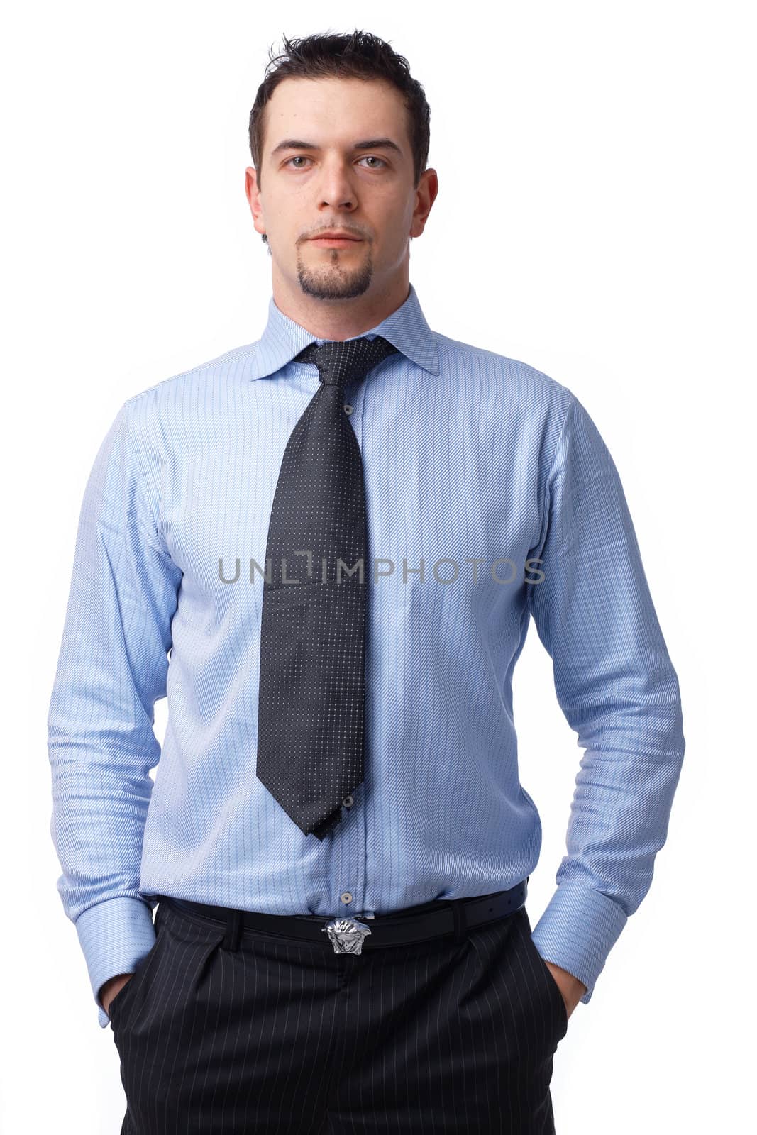 Portrait of a confident businessman standing with his hands in the pockets on white.