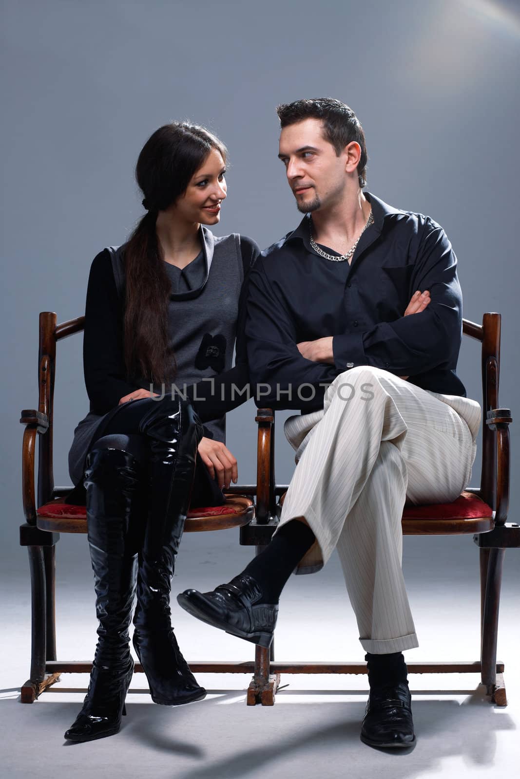 Young couple sitting on a theatrical bench looking at each other.
