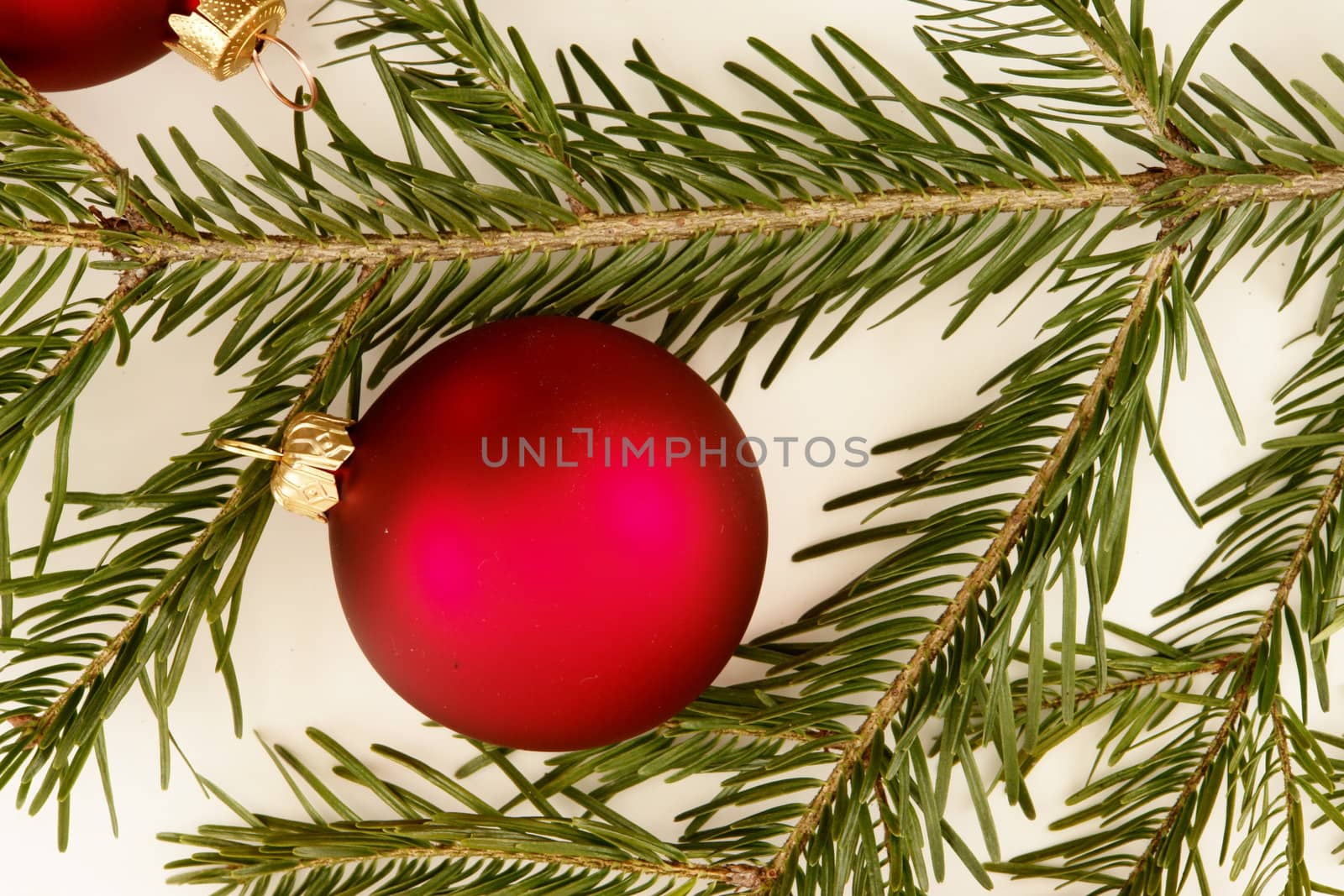 Border of red christmas garland with baubles and ribbons on white.