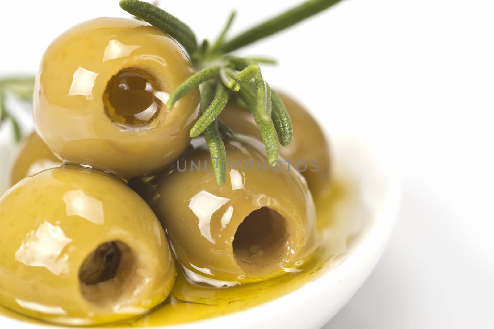 Pitted olives in a saucer isolated on a white background.