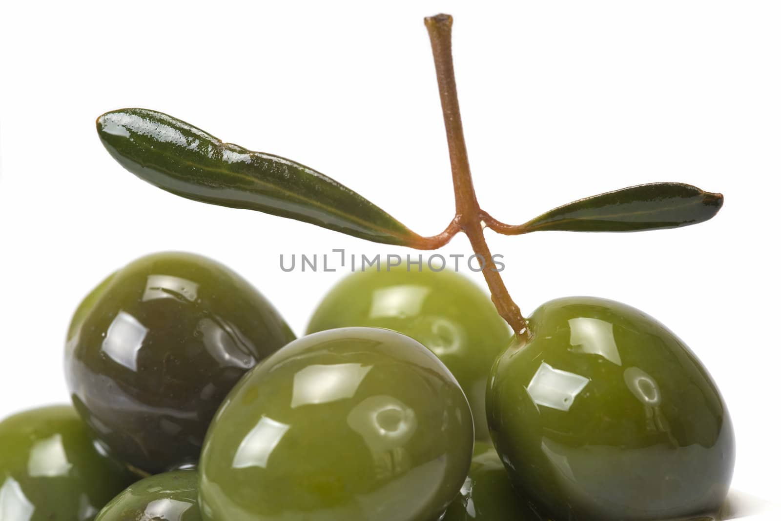 Green olives in a china spoon over a white background
