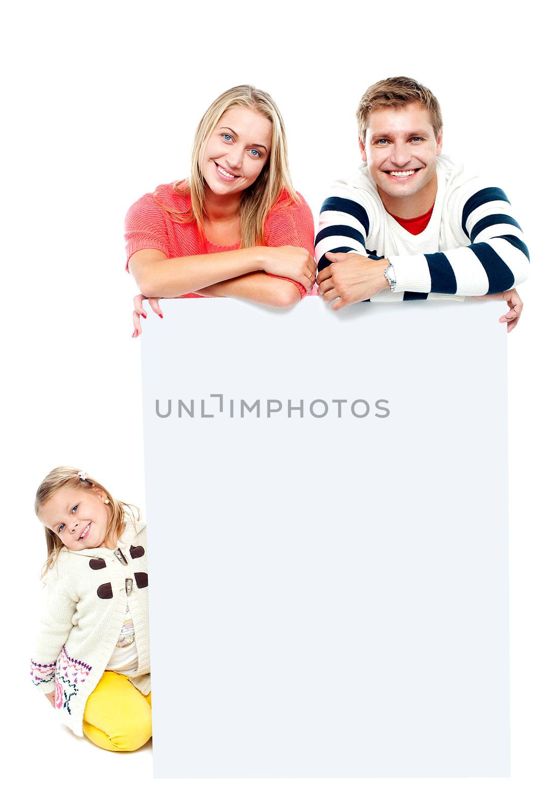 Couple standing behind blank white ad board while their daughter sitting on the floor