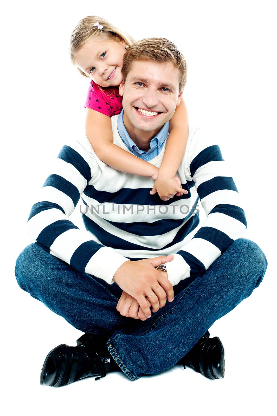 Father in winter wear sitting on the floor with his legs crossed and his daughter holding him from behind