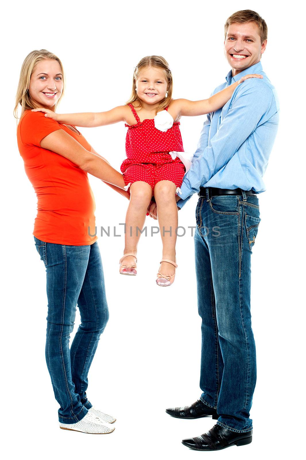 Baby girl sitting on outstretched arms of her parents by stockyimages