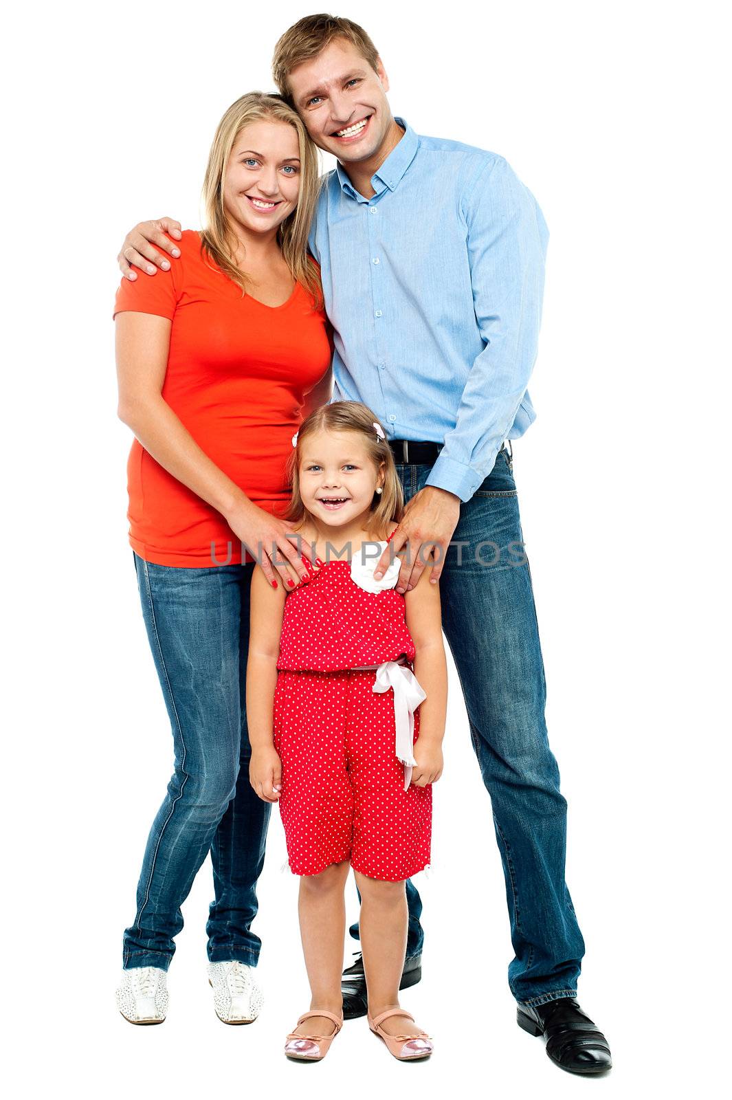 Happy family. Mother, father and cute daughter posing in trendy outfits