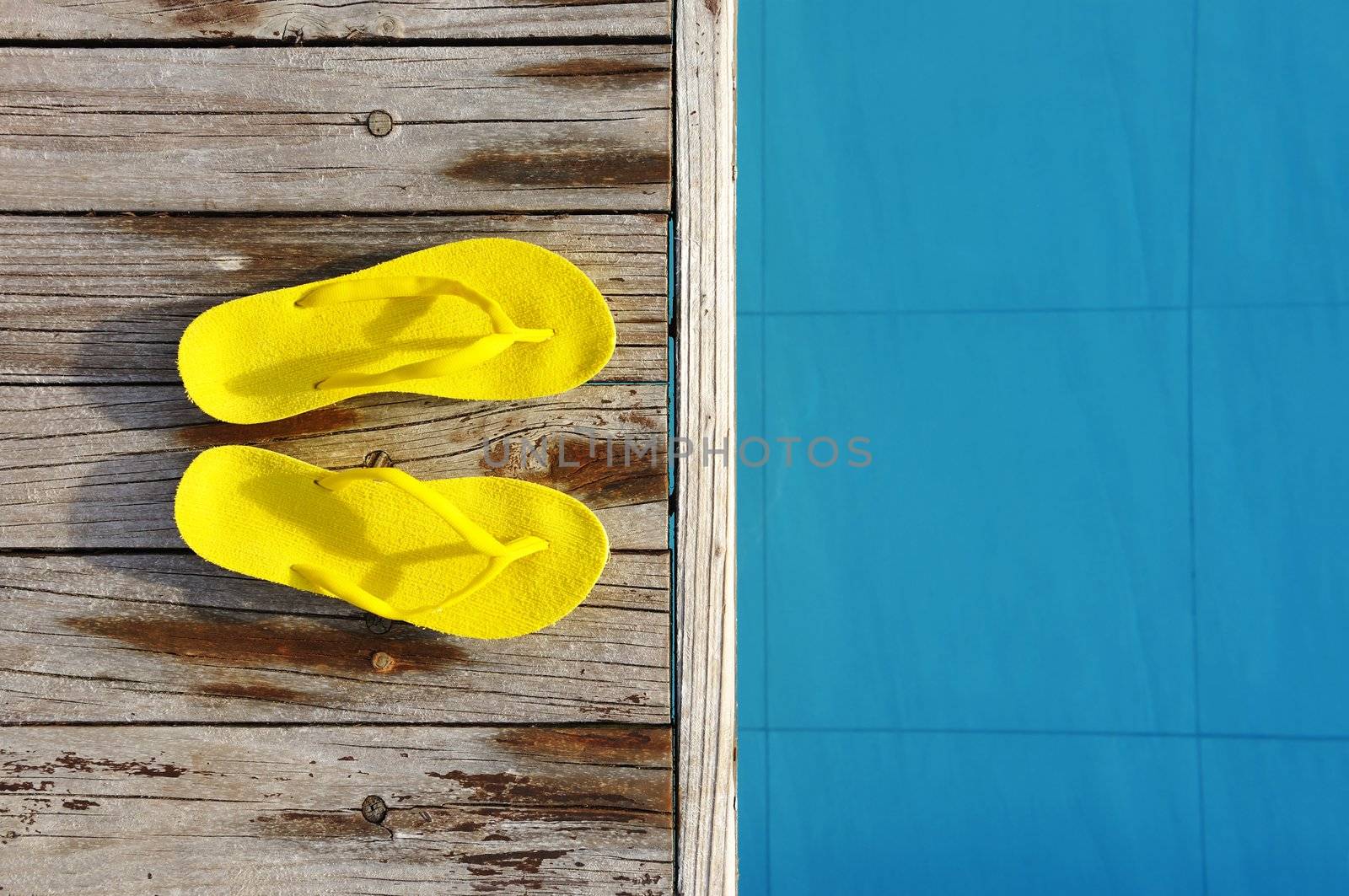 Yellow sandals by a swimming pool 