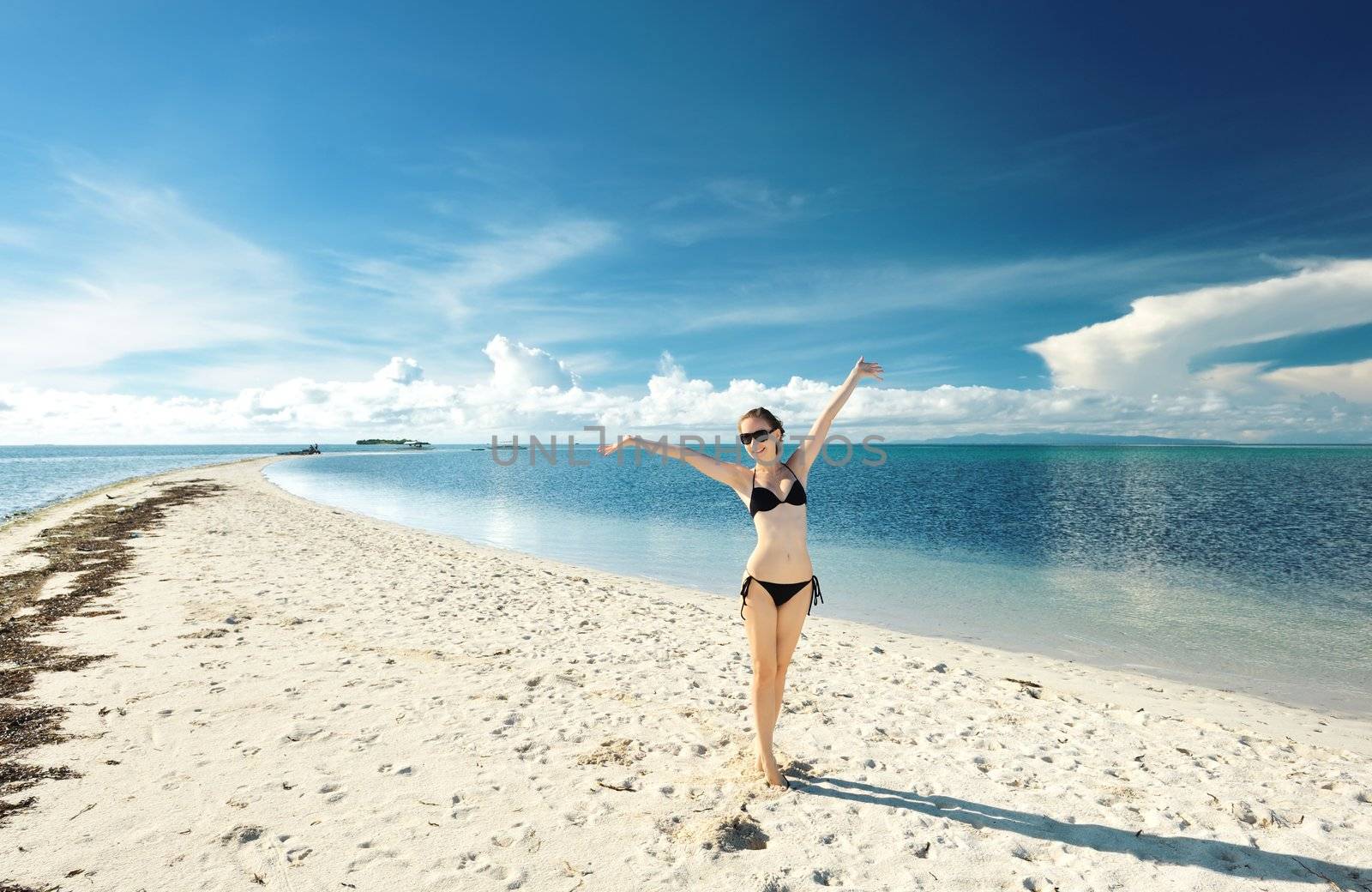 Girl on a tropical beach with outstretched arms