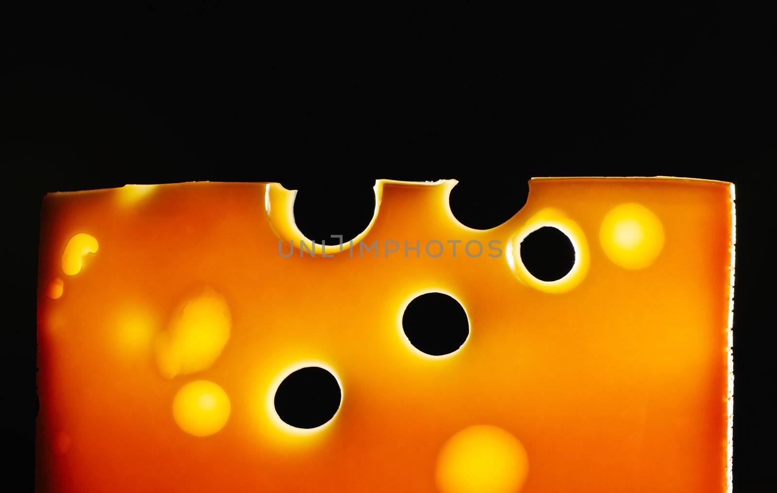 Swiss cheese over black background