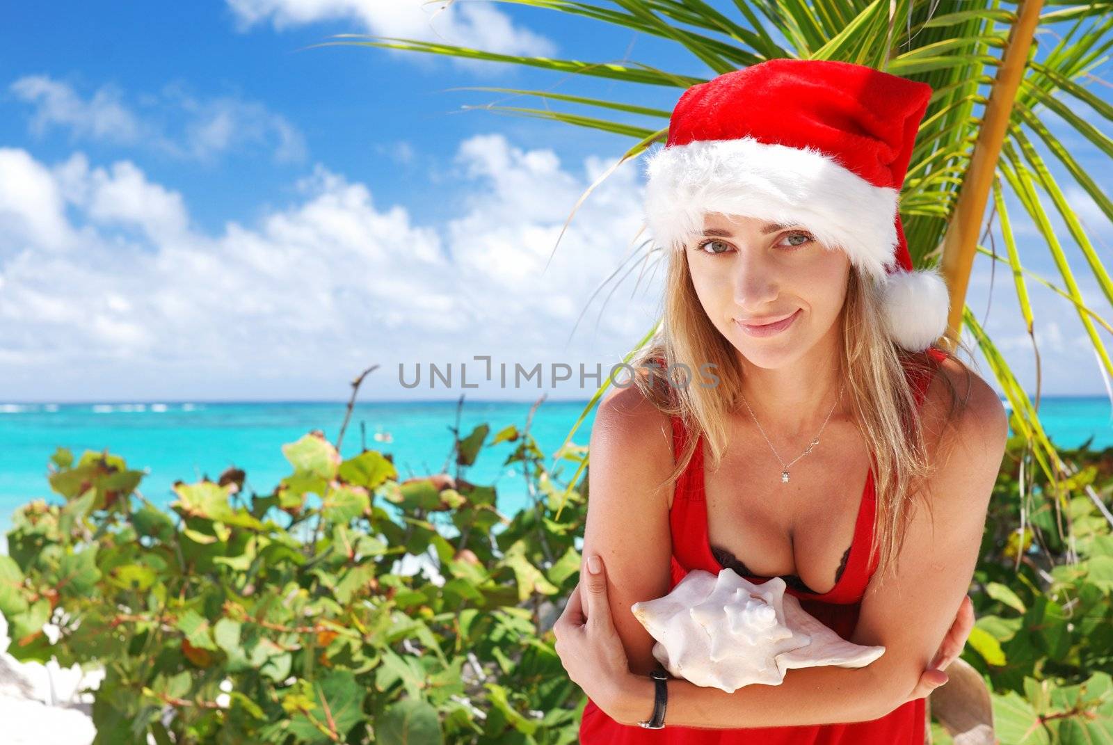 Woman on the beach in santa's hat