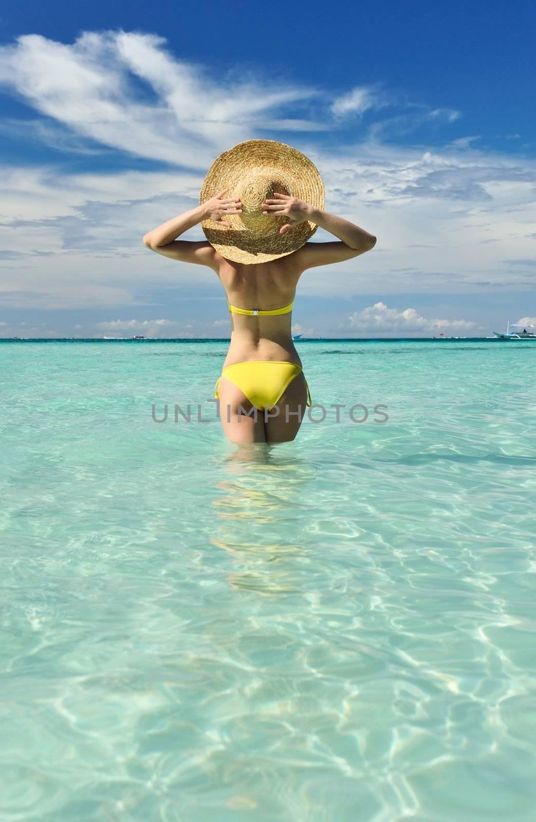 Girl on a tropical beach with hat