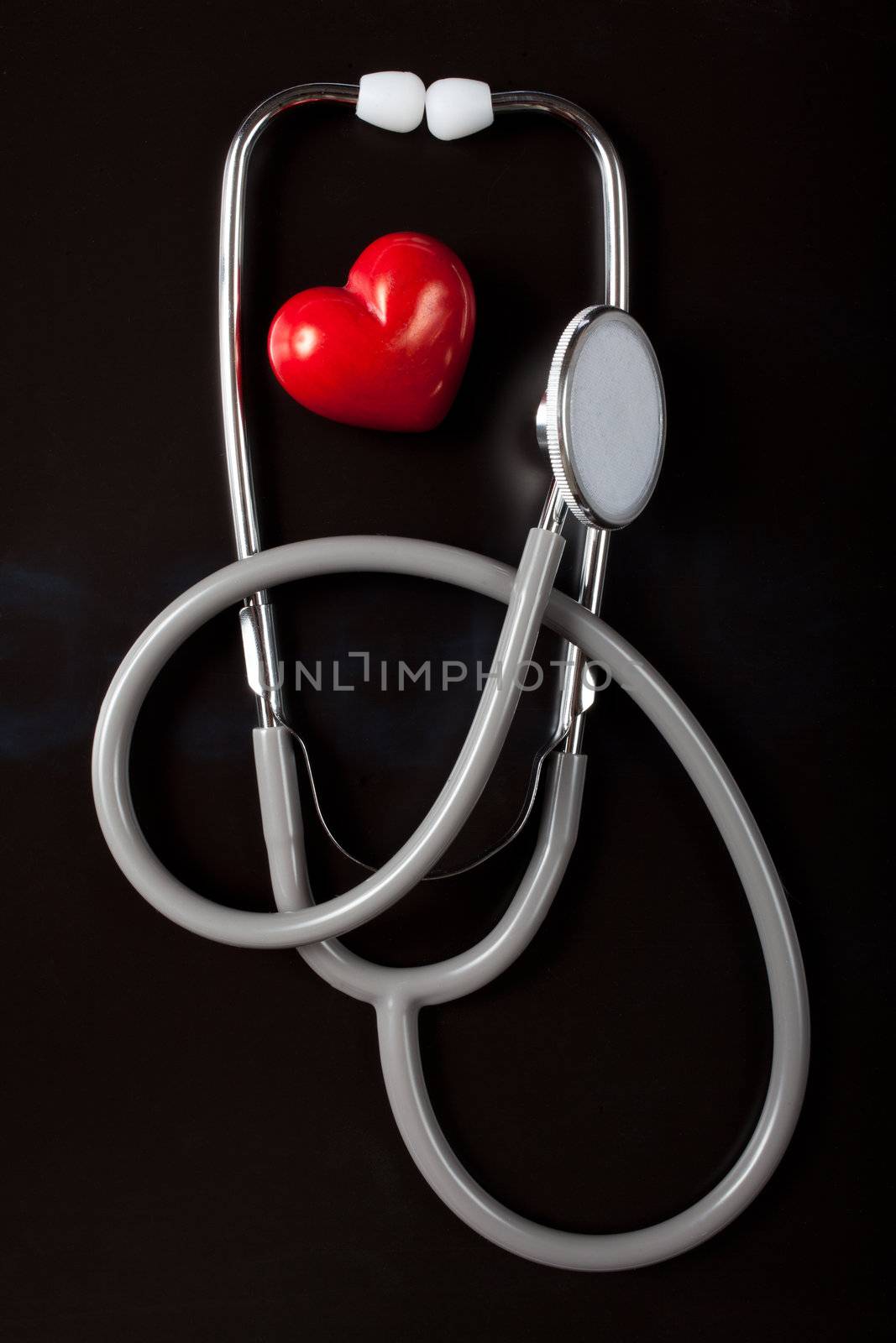 Stethoscope & red heart on black background